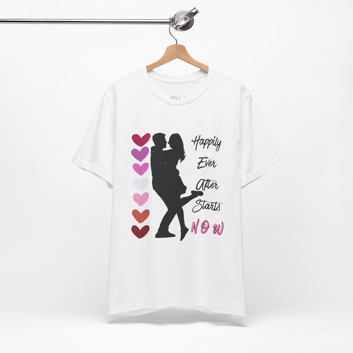 White t-shirt with a black graphic design of two people embracing between stacked hearts and text 'Happily Ever After Starts Now'
