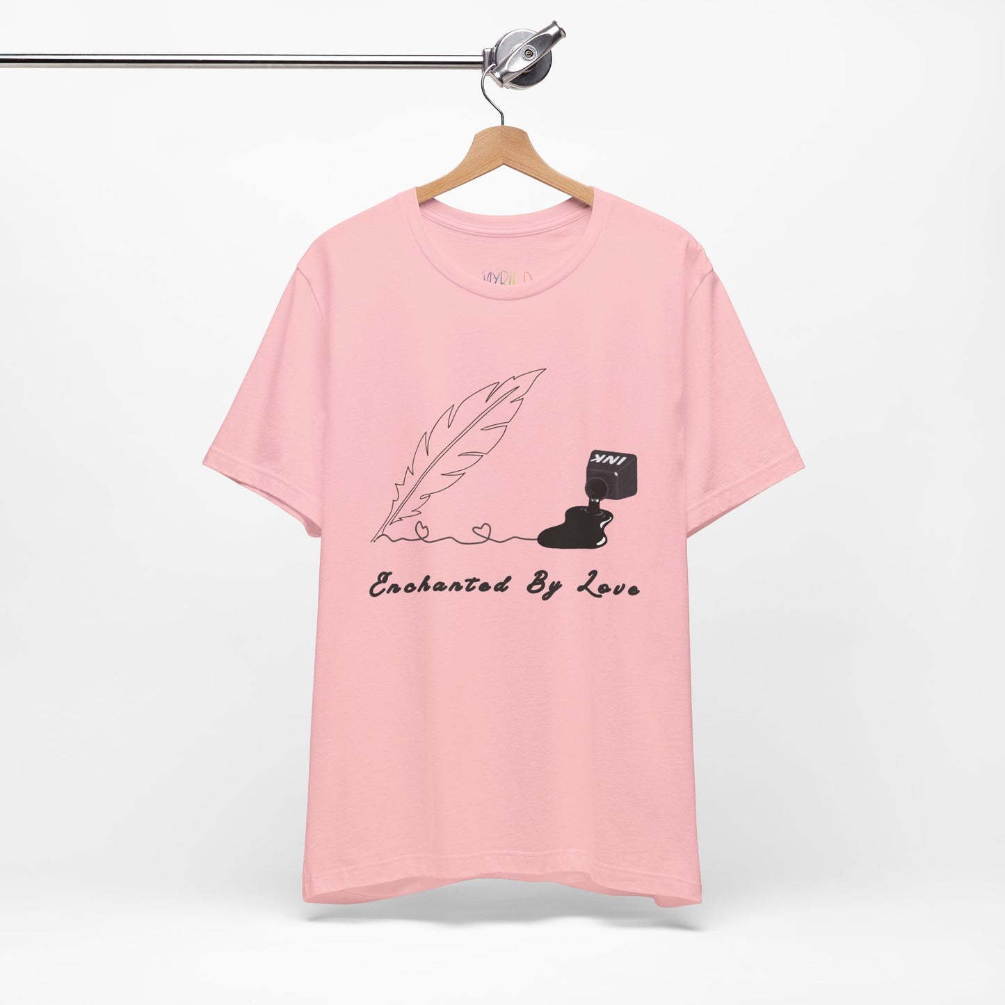 Pink t-shirt with a black sketched feather quill, spilled ink and text 'Enchanted By Love'