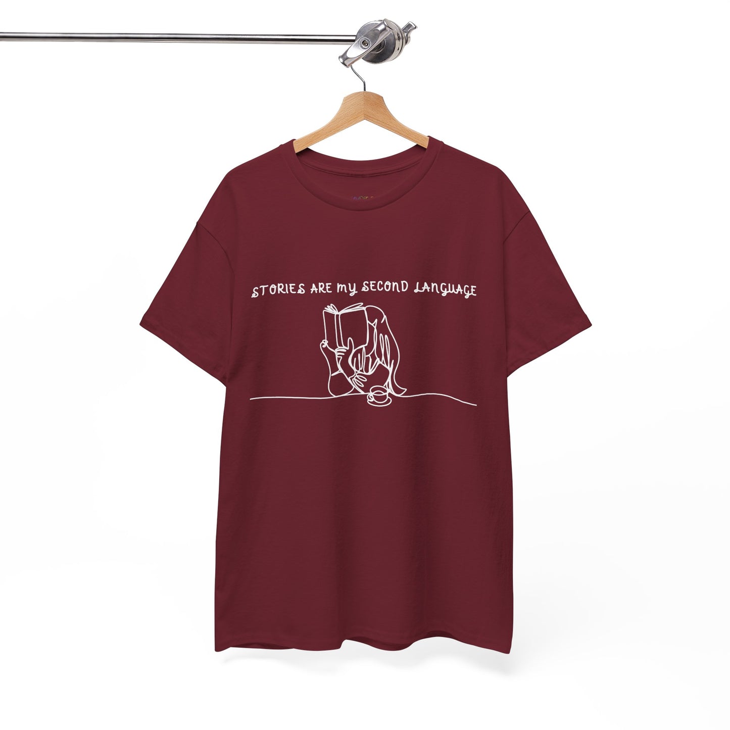 Red t-shirt with a white sketched design of of girl reading a book and text 'Stories Are My Second Language'