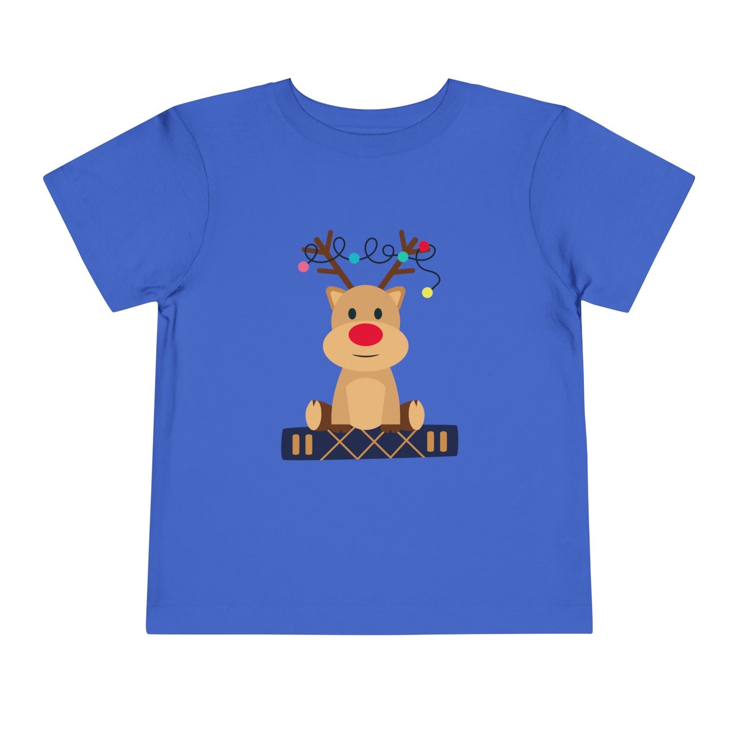 Blue toddler t-shirt with a baby reindeer sitting on a book, a string of Christmas lights in it's antlers, on a white background