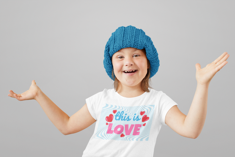Little girl wearing a blue knit hat and a white t-shirt with 'this is love' text by Jaybie D.