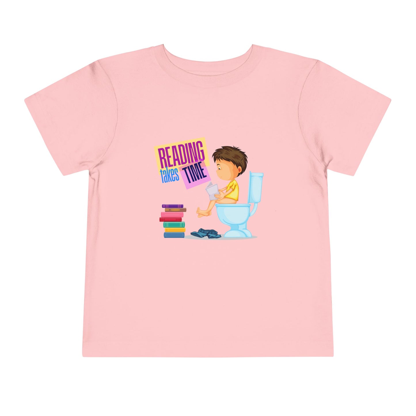 Pink t-shirt with a graphic of a child reading on a toilet, a stack of books at his feet, and colorful 'Reading Takes Time' text.