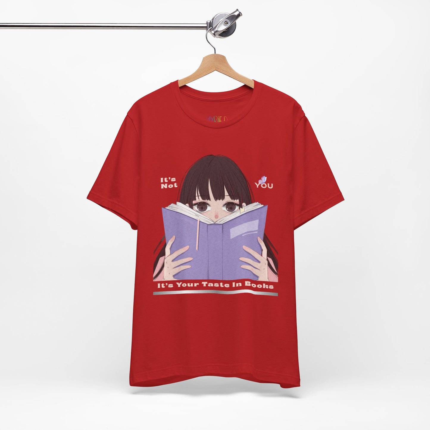 Red t-shirt with graphic design of a girl peeking over the top of a book and text 'It's Not You. It's Your Taste In Books.'