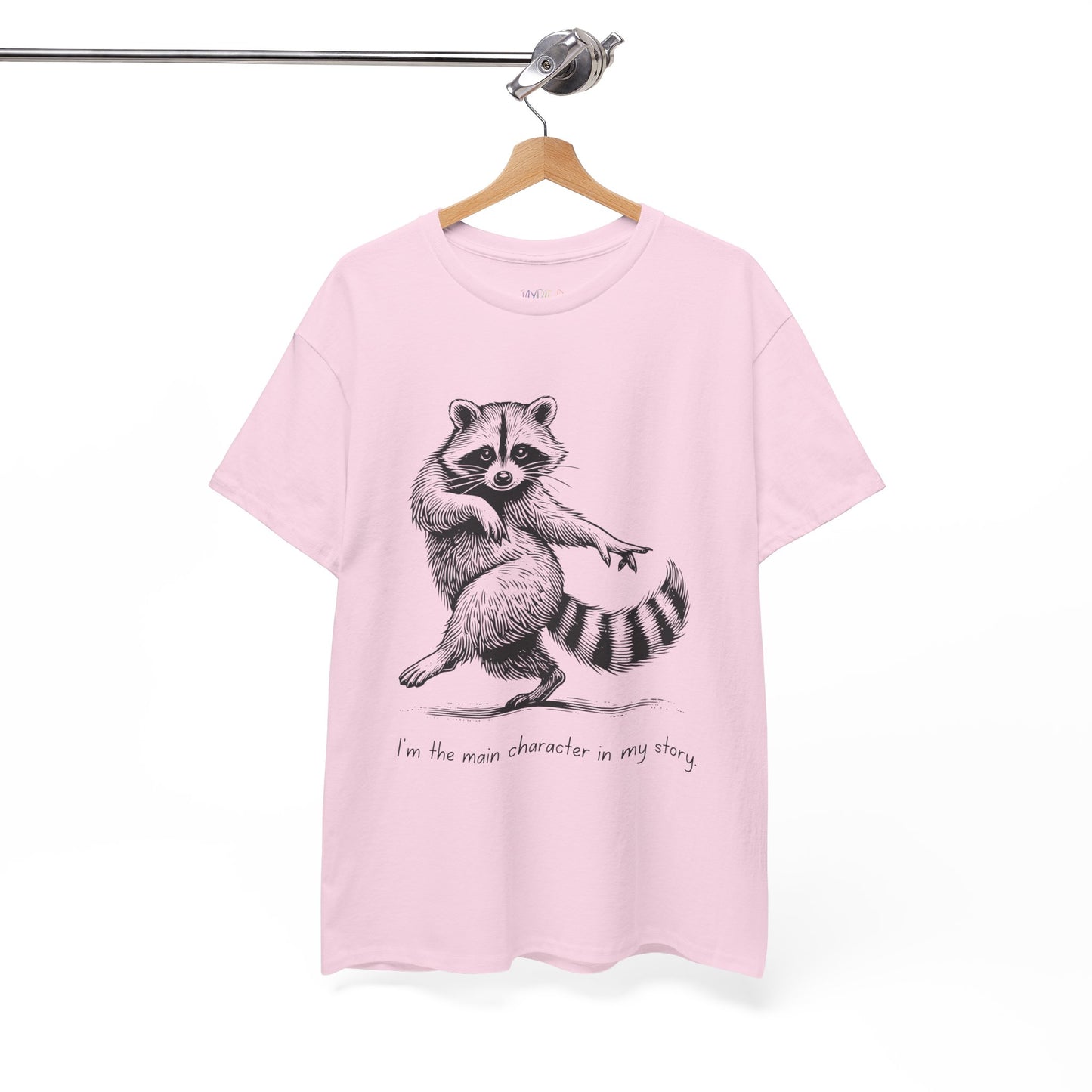 Light pink t-shirt with a dancing raccoon graphic and text 'I'm the main character in my story'