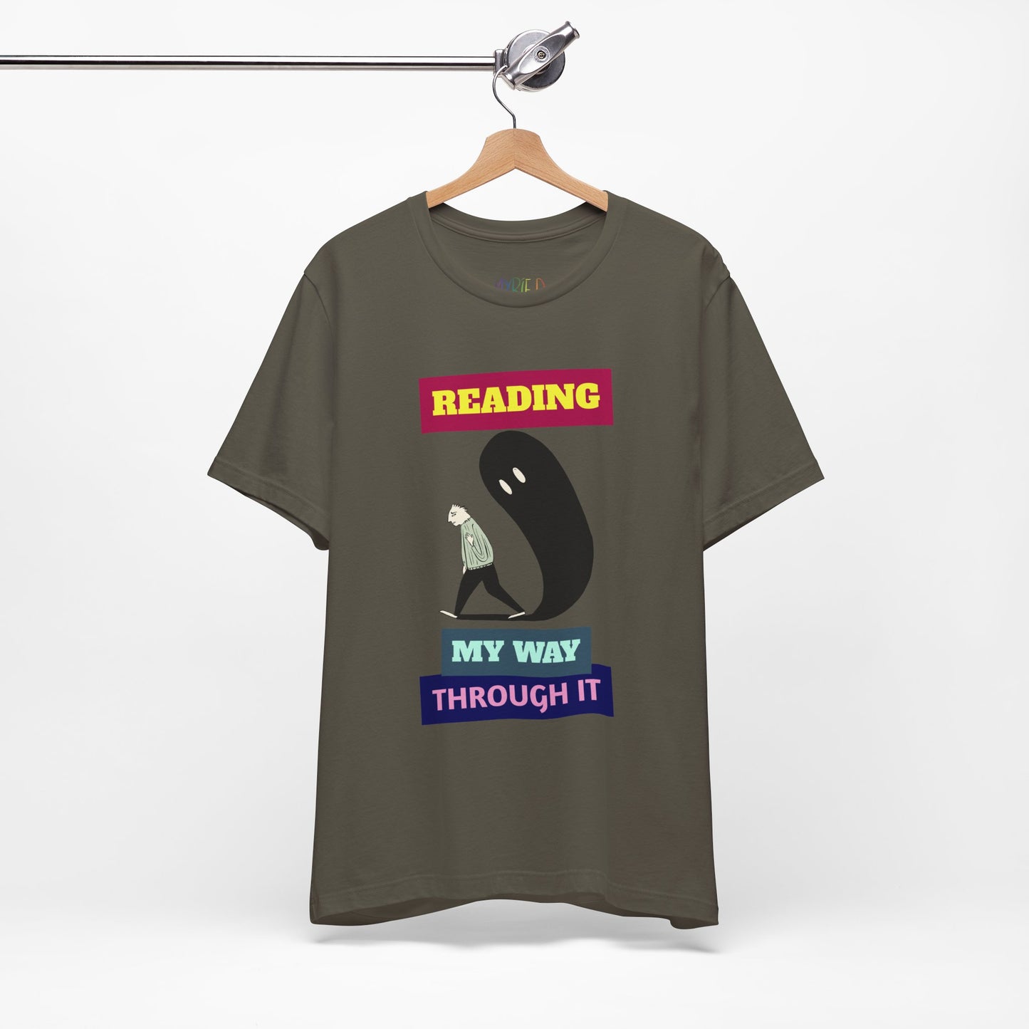 Army green t-shirt with graphic of a person walking, followed by a looming shadow and text 'Reading My Way Through It'