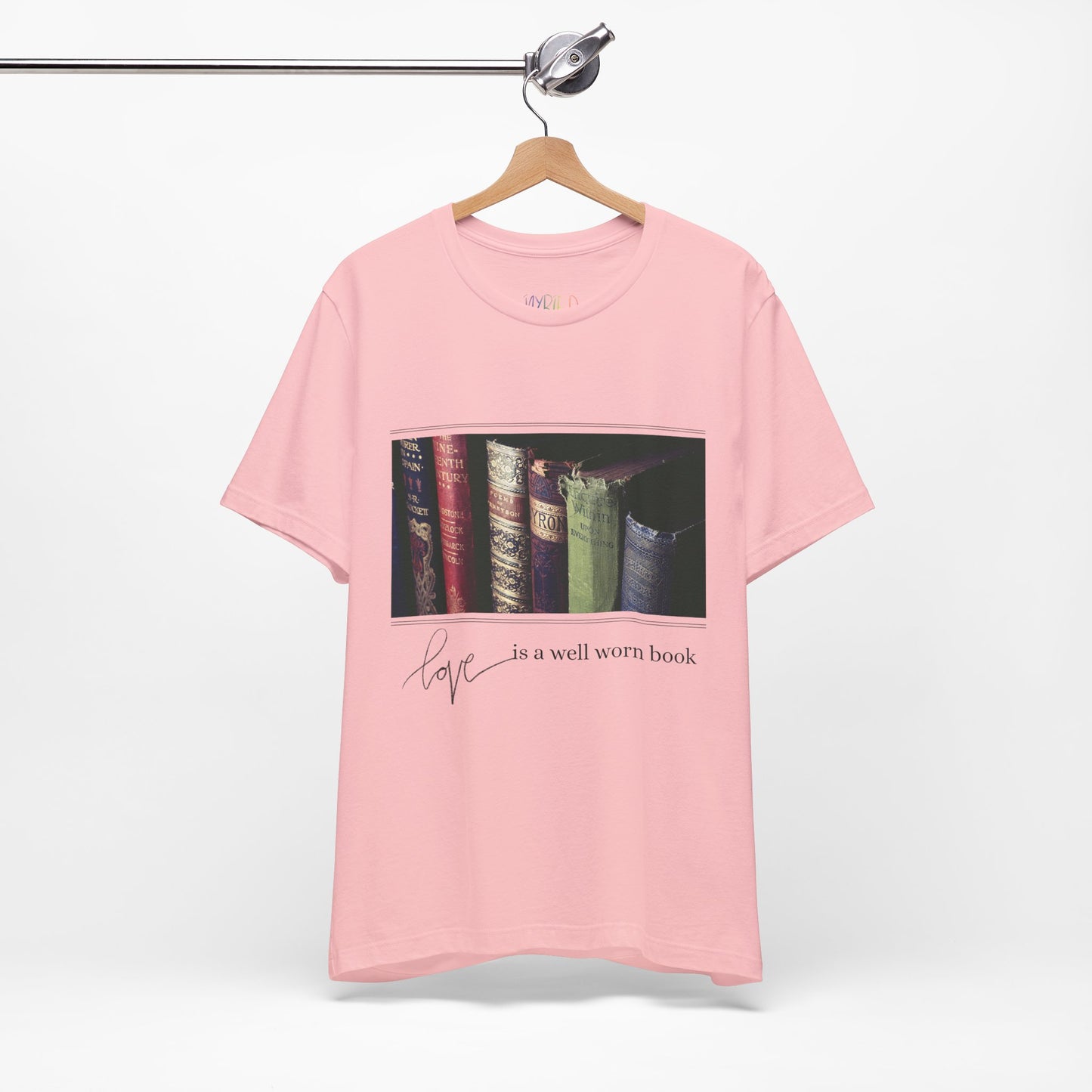 Pink t-shirt with a row of old books and text 'Love Is A Well Worn Book'