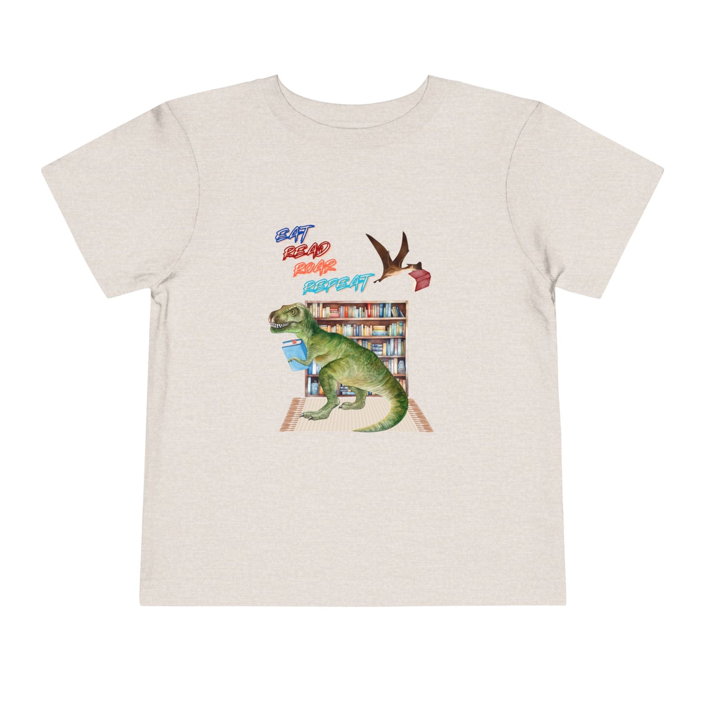 Tan toddler t-shirt with a t-rex dinosaur checking out a book at the library, a tera dactyl flying overhead with a book and text 'Eat, Read, Roar, Repeat'