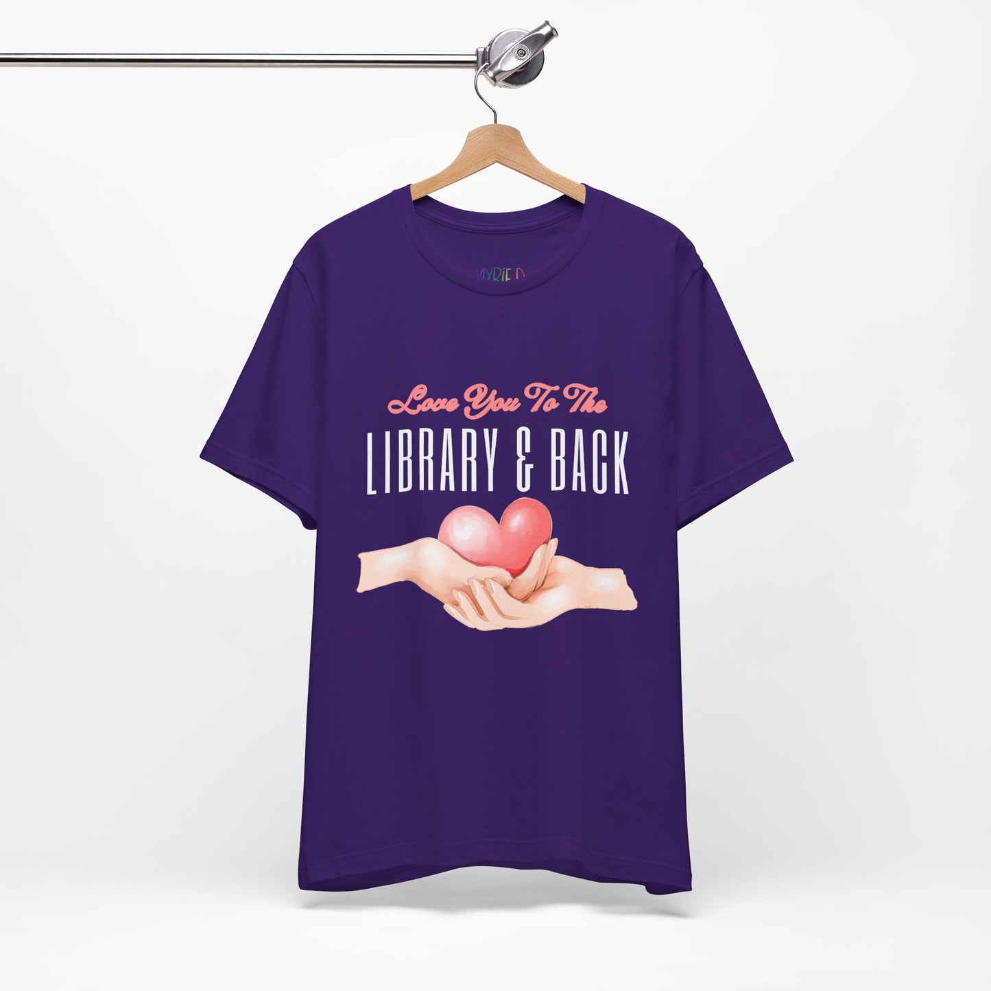 Purple t-shirt with graphic design of two hands holding a heart and text 'Love You To The Library & Back'