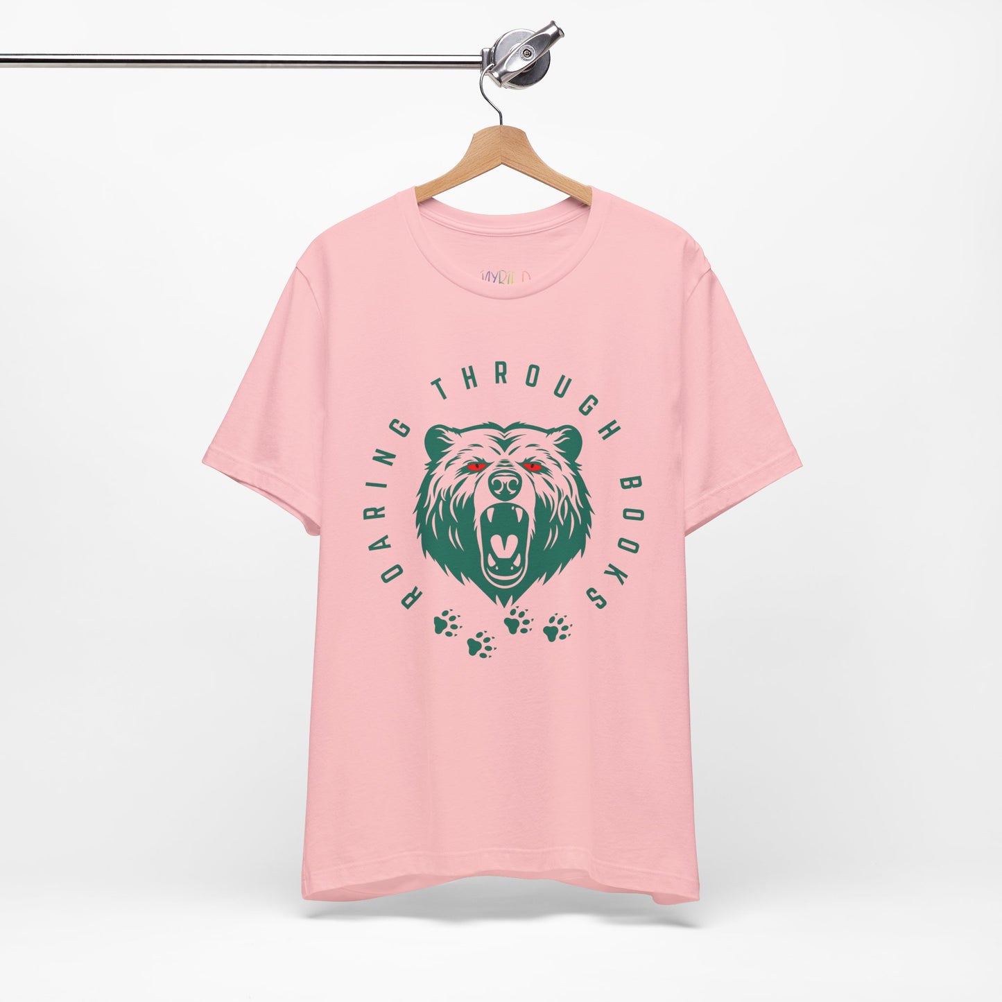 Pink t-shirt with a green bear graphic, red eyes and circular text 'Roaring Through Books'