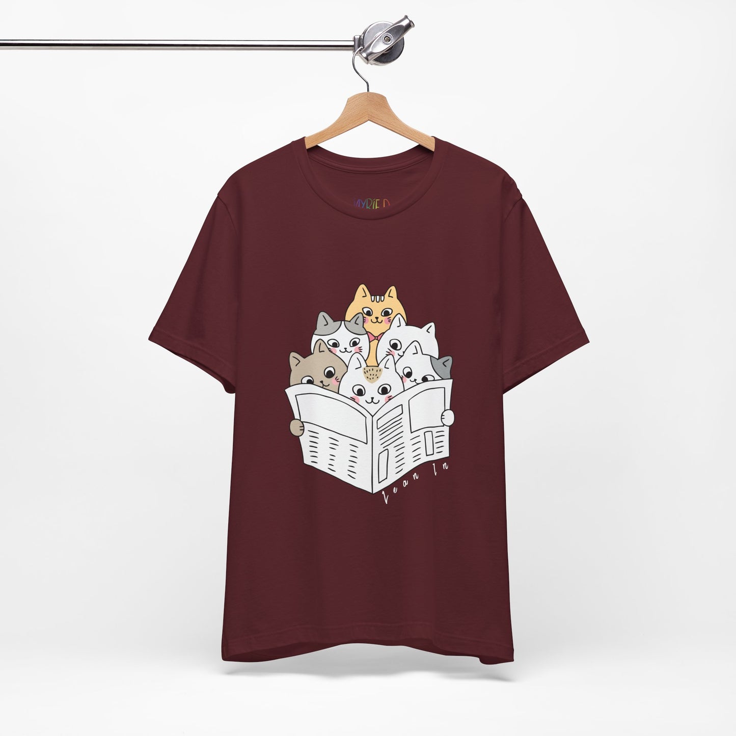 Maroon t-shirt with cartoon cats squeezed in to read the newspaper and text 'Lean In'