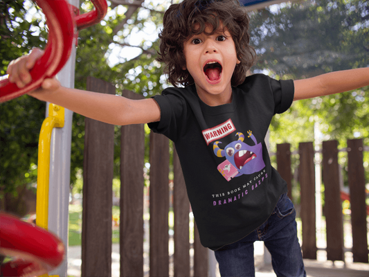 Young boy on playground equipment, wearing a bookish monster t-shirt by Jaybie D.