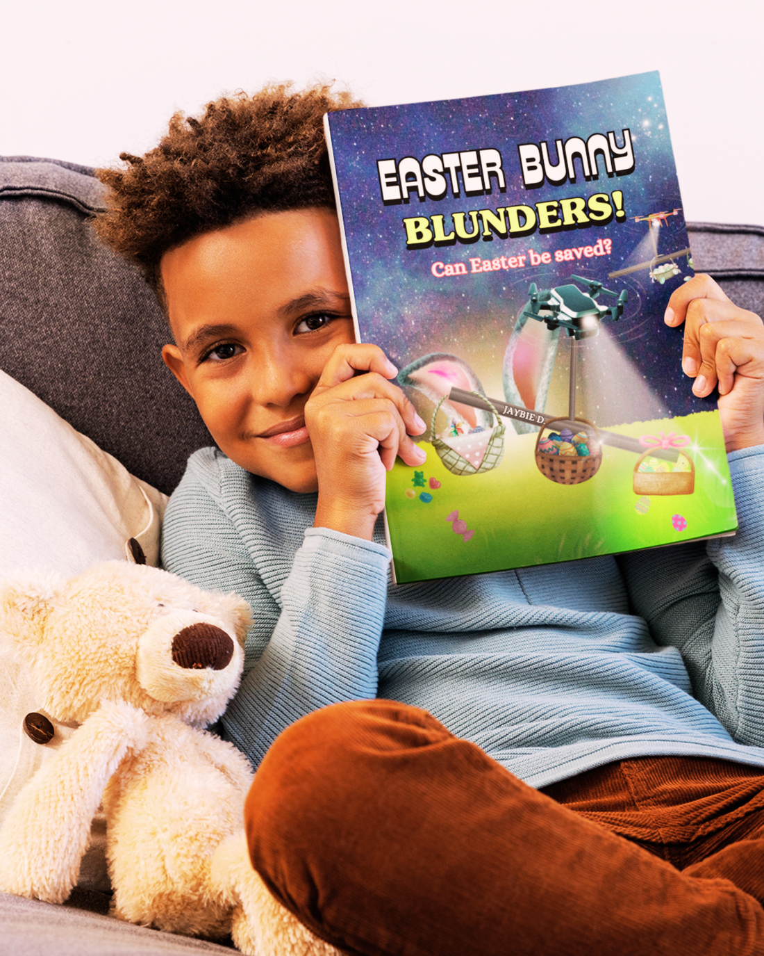 Boy sitting on the couch with his stuffed animal and the children's picture book Easter Bunny Blunders by Jaybie D.