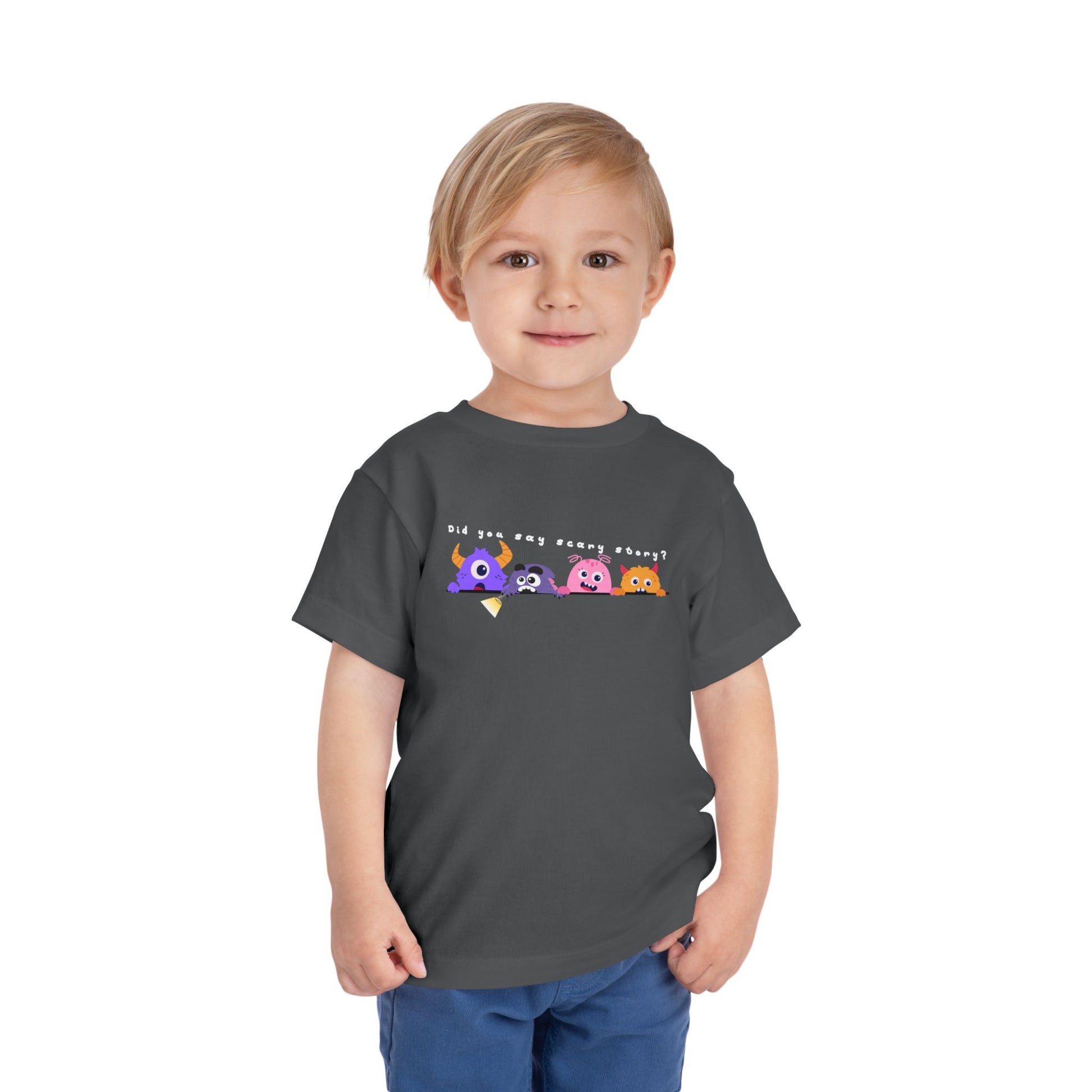 Toddler wearing a gray t-shirt with a row of scared cartoon monsters peeking over a ledge and text 'Did You Say Scary Story?'