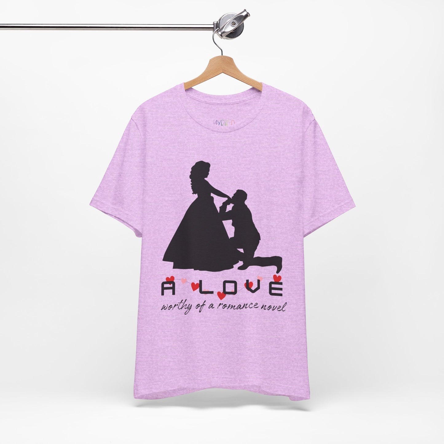 Light purple t-shirt with black graphic if a man kneeling in front of a woman in a gown and text 'A LOVE worthy of a romance novel'