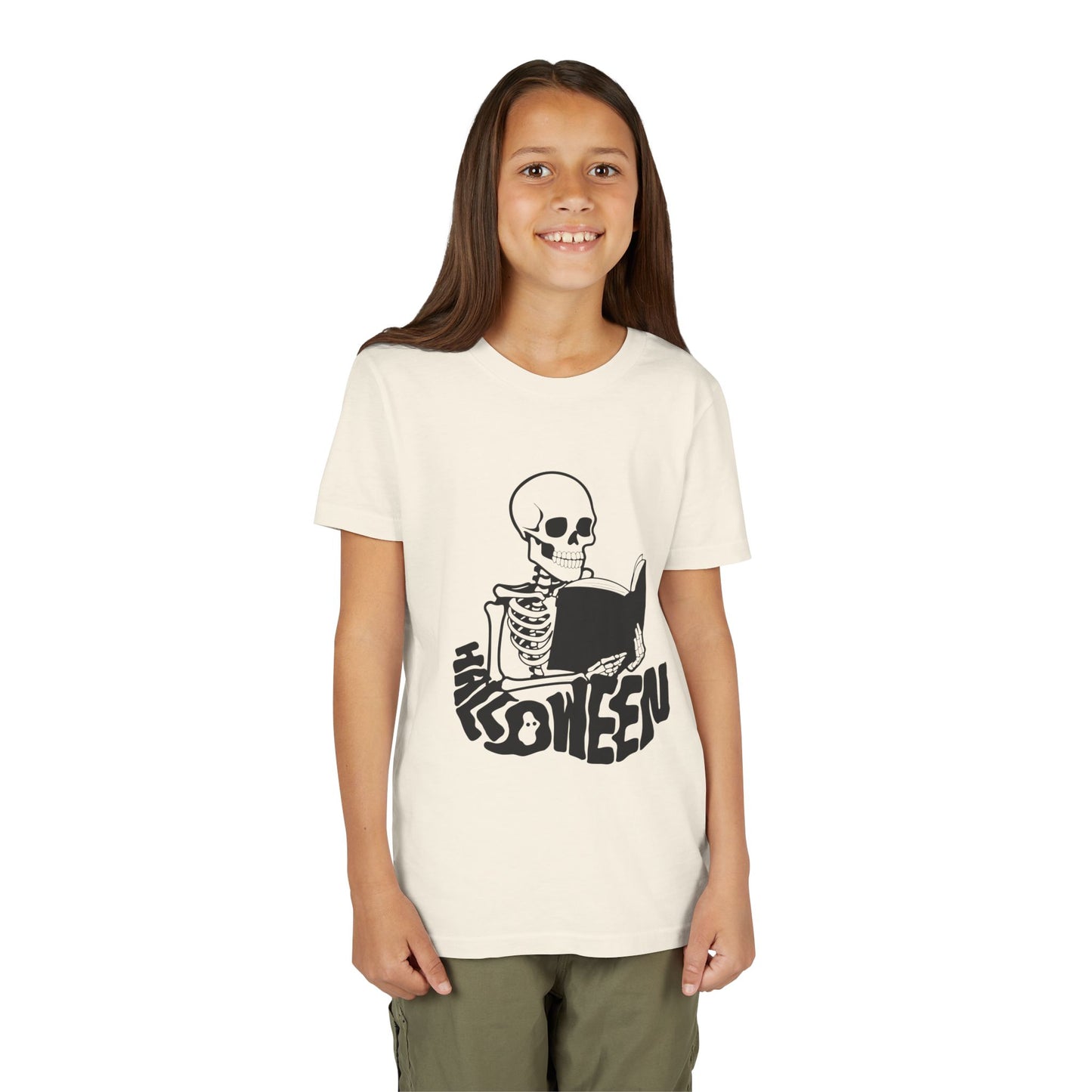 Girl wearing a beige t-shirt with a black skeleton reading a book and 'Halloween' text spelled out in a spooky font