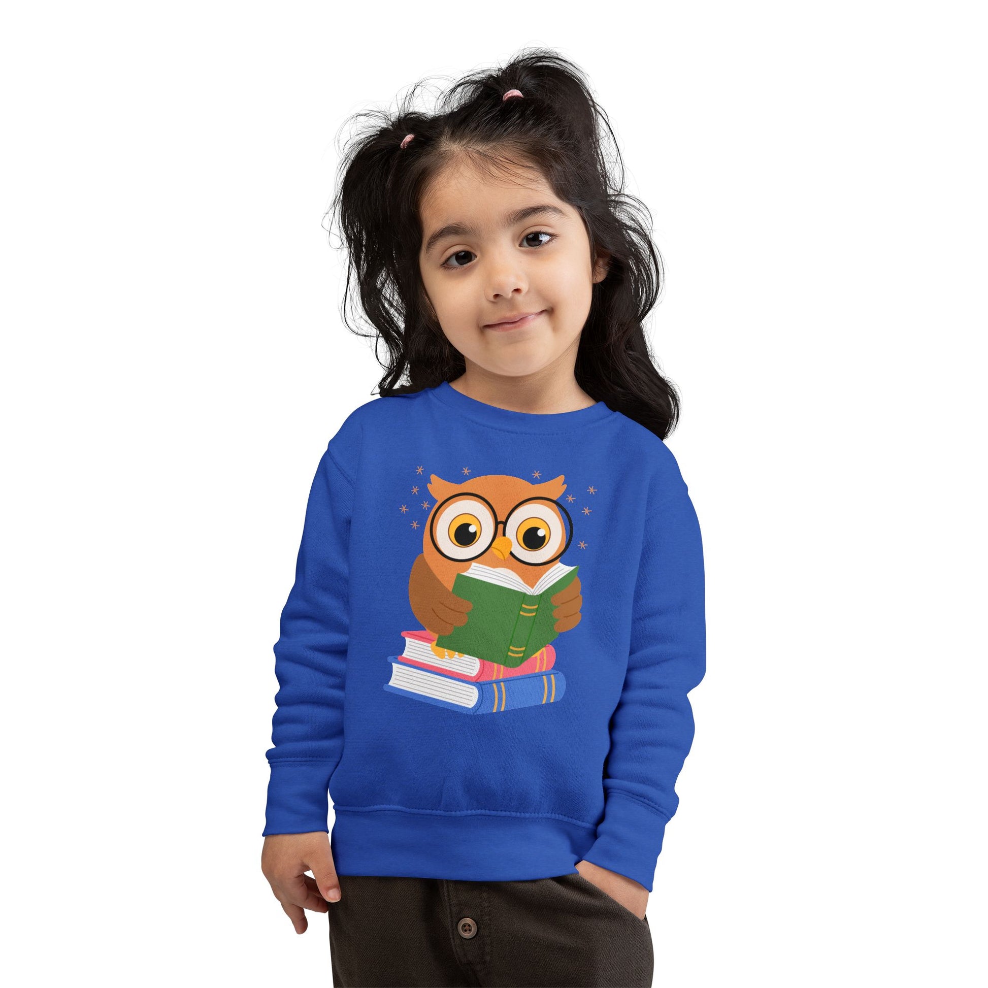 Girl wearing a blue toddler sweatshirt with an owl reading a book 