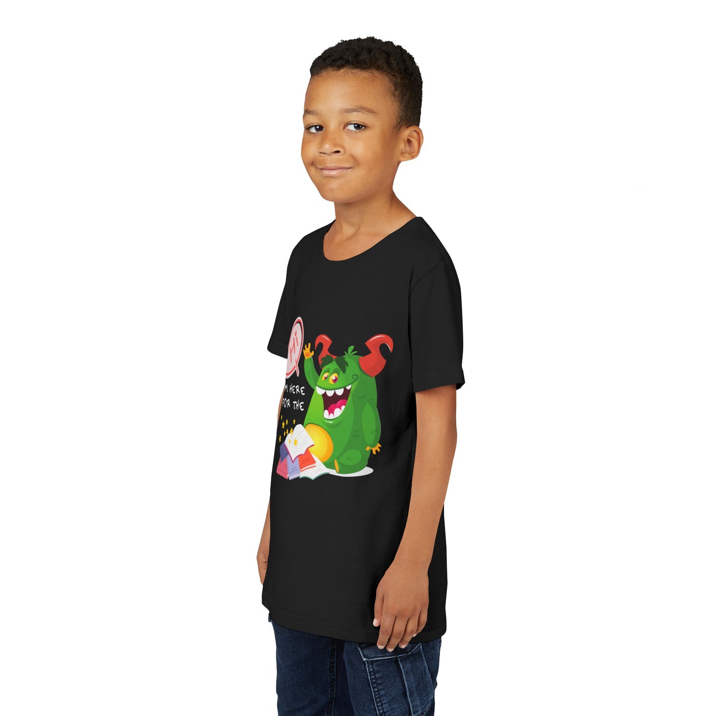 Boy wearing a black t-shirt with a chubby green monster waiving, with text 'Hi, I'm Here For The' above a messy stack of books