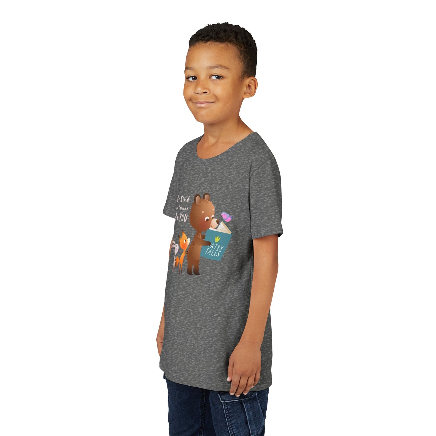 Boy wearing a gray t-shirt with cartoon animals reading a fairy tales book and text 'Be Kind. Be Curious. Be YOU.'