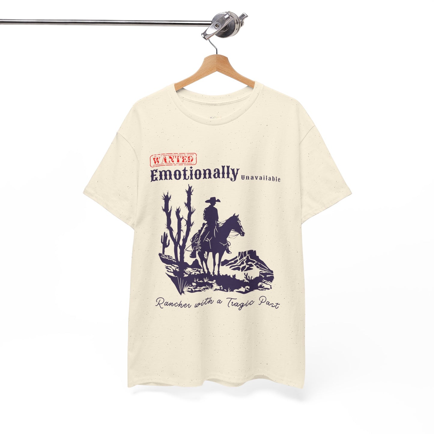 Beige t-shirt with a horse riding cowboy in a desert setting and text 'WANTED Emotionally Unavailable Rancher With A Tragic Past'