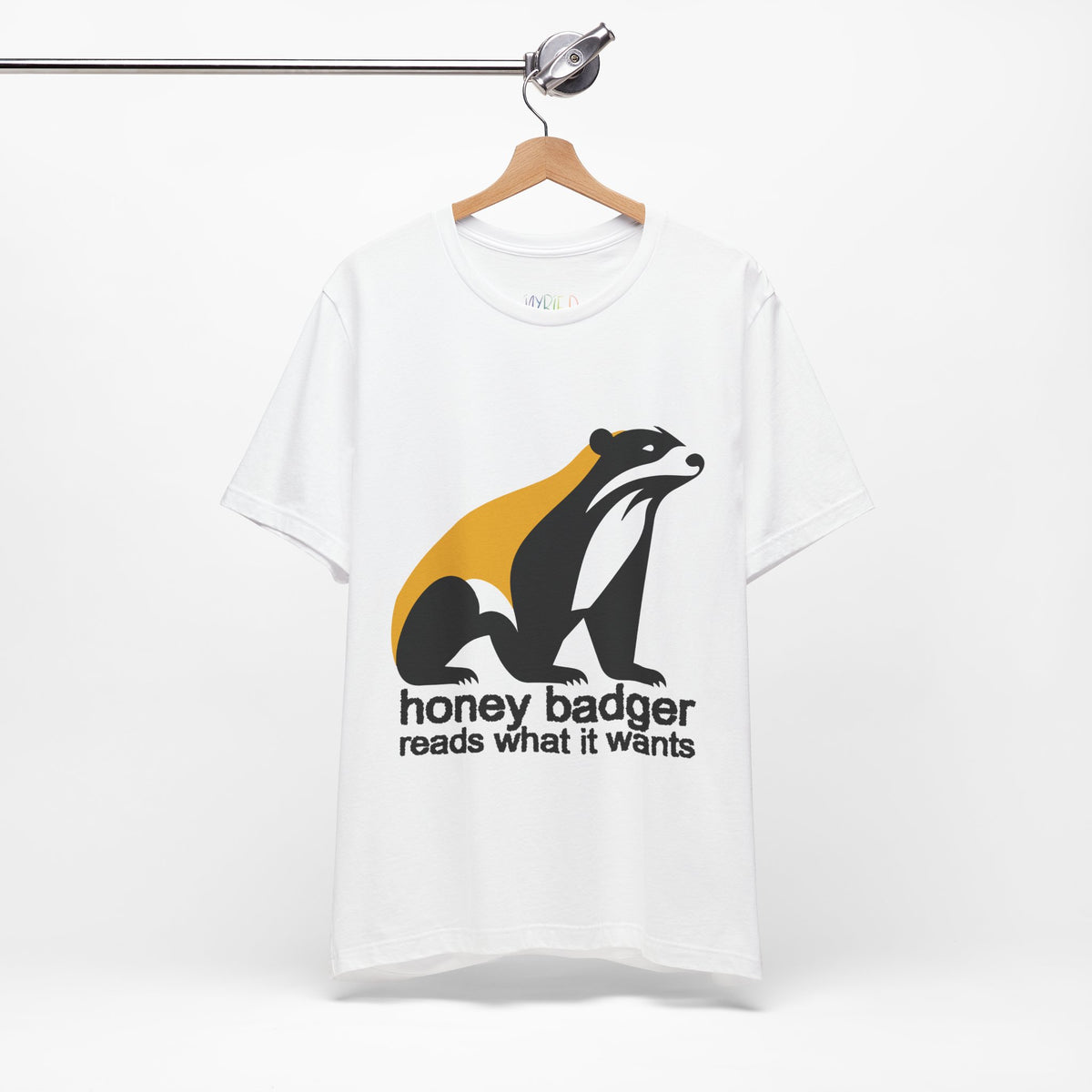 White t-shirt featuring a large black yellow and white badger with text "honey badger reads what it wants"