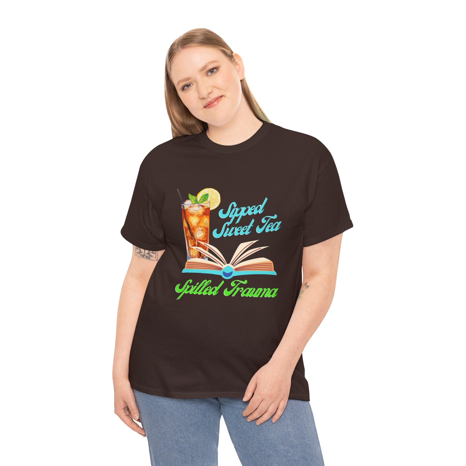 Woman wearing a brown t-shirt with a graphic design of a  sweet ice tea, an open book and text 'Sipped Sweet Tea, Spilled Trauma'