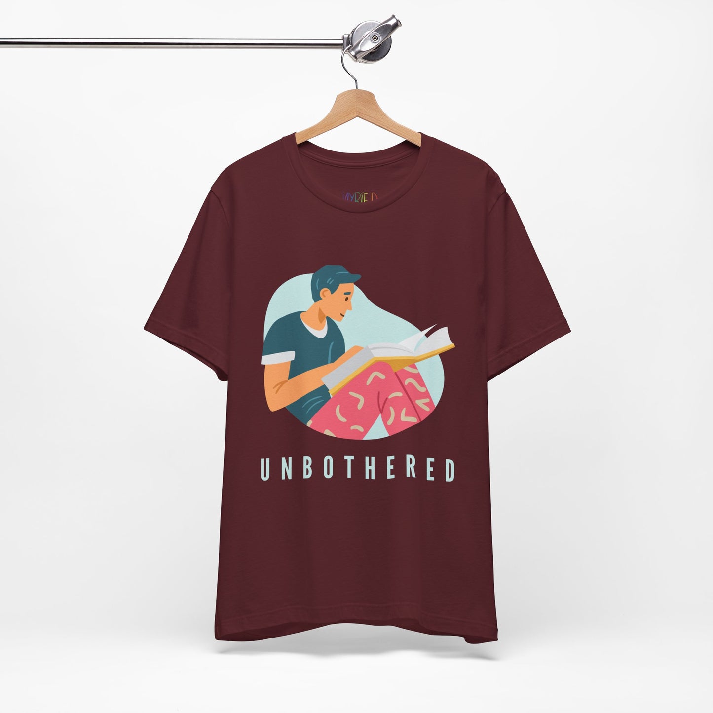 Maroon t-shirt with a man reading a book and 'UNBOTHERED' text 