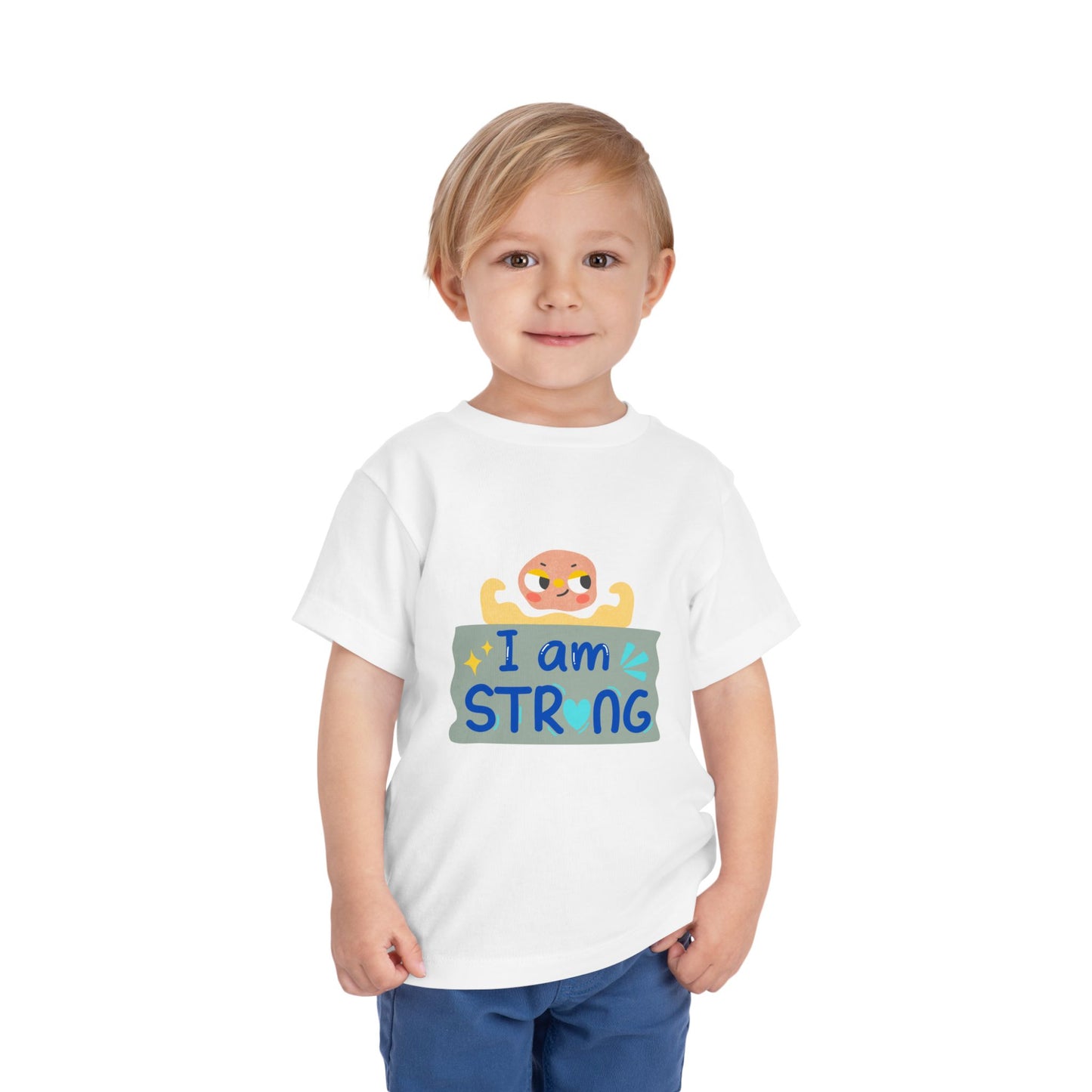 Child wearing a white toddler t-shirt with a cartoon character showing its arm muscles and 'I am strong' text
