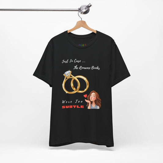 Black t-shirt with graphic design of two wedding rings and a woman blowing a kiss, with text that says 'Just In Case... The Romance Books Were Too Subtle' 