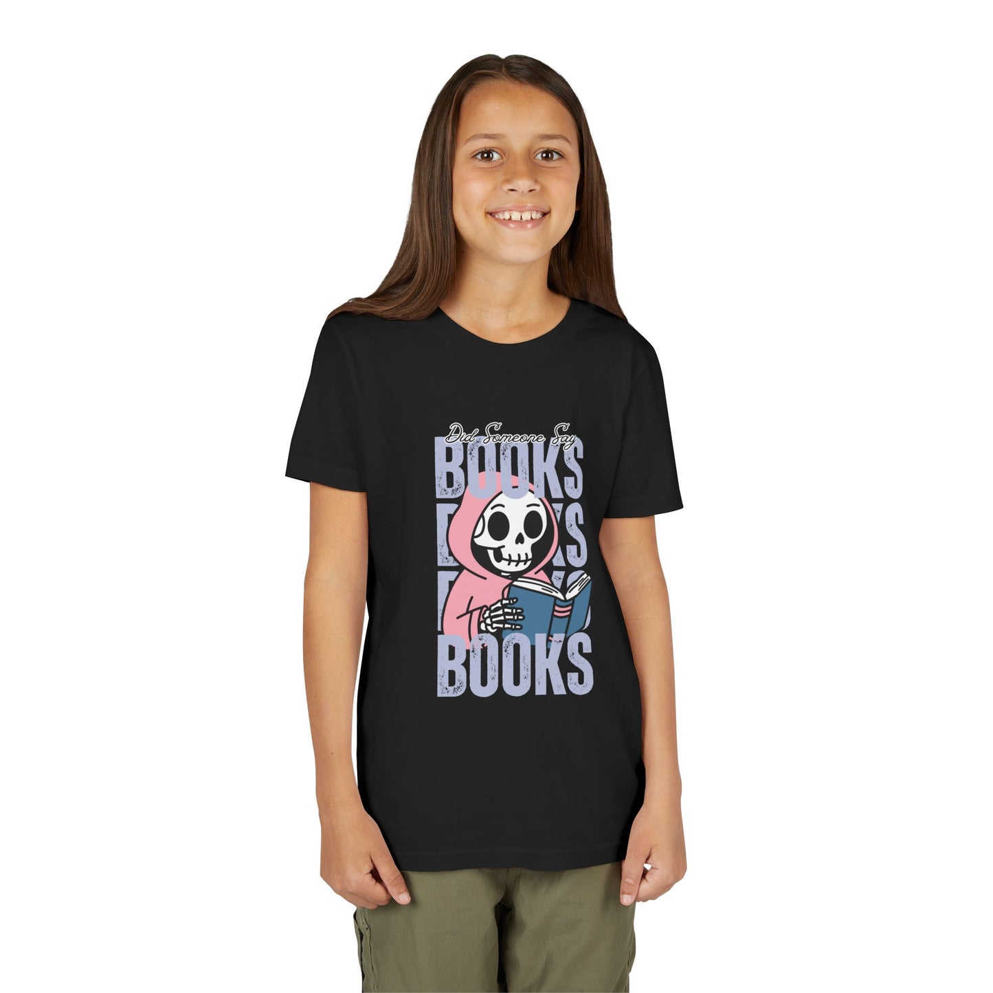 Girl wearing a black t-shirt with a skeleton in a pink hoodie, reading a book in the middle of stacked 'BOOKS' text
