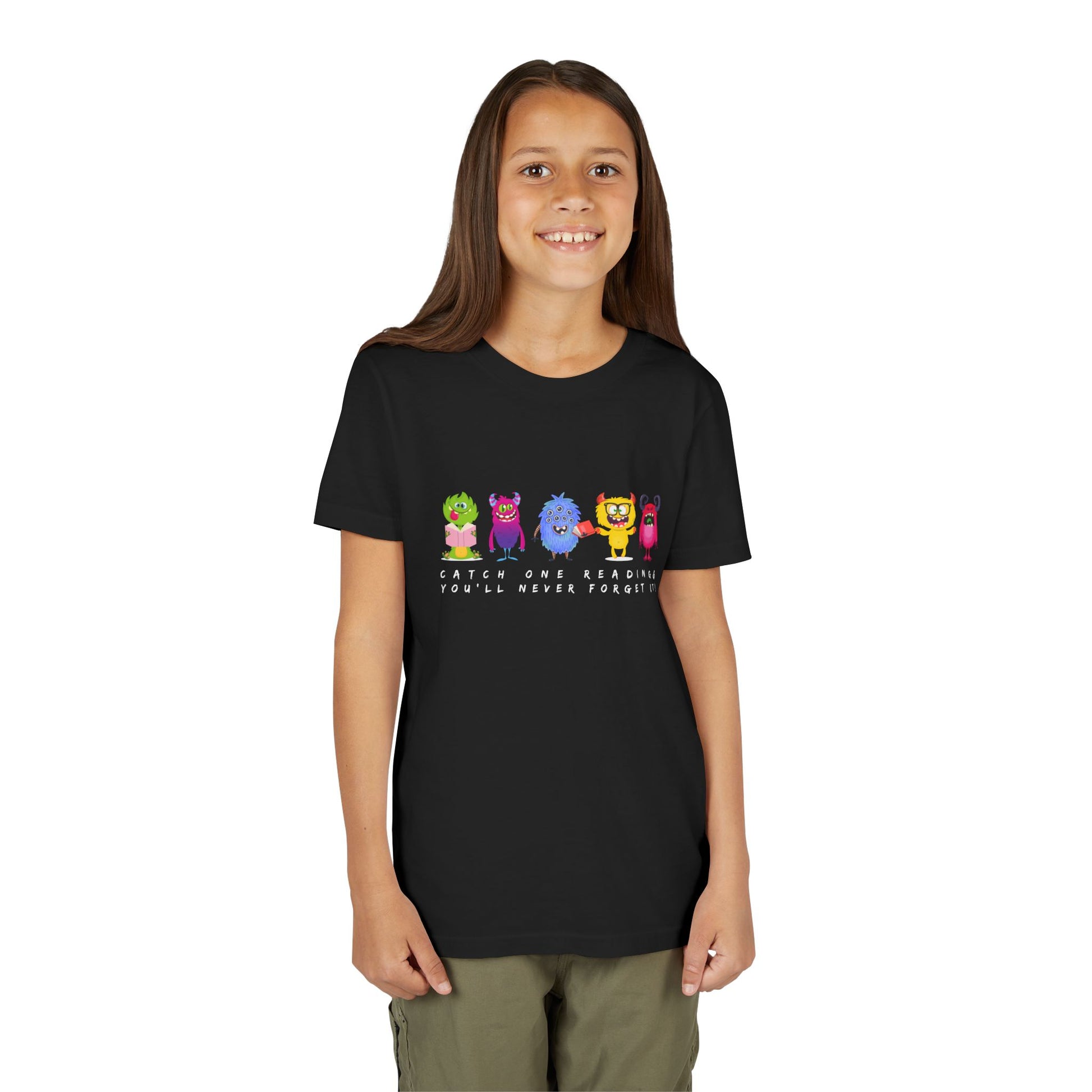 Girl wearing a black t-shirt with a row of colorful cartoon monster characters and text 'Catch One Reading & You'll Never Forget It'