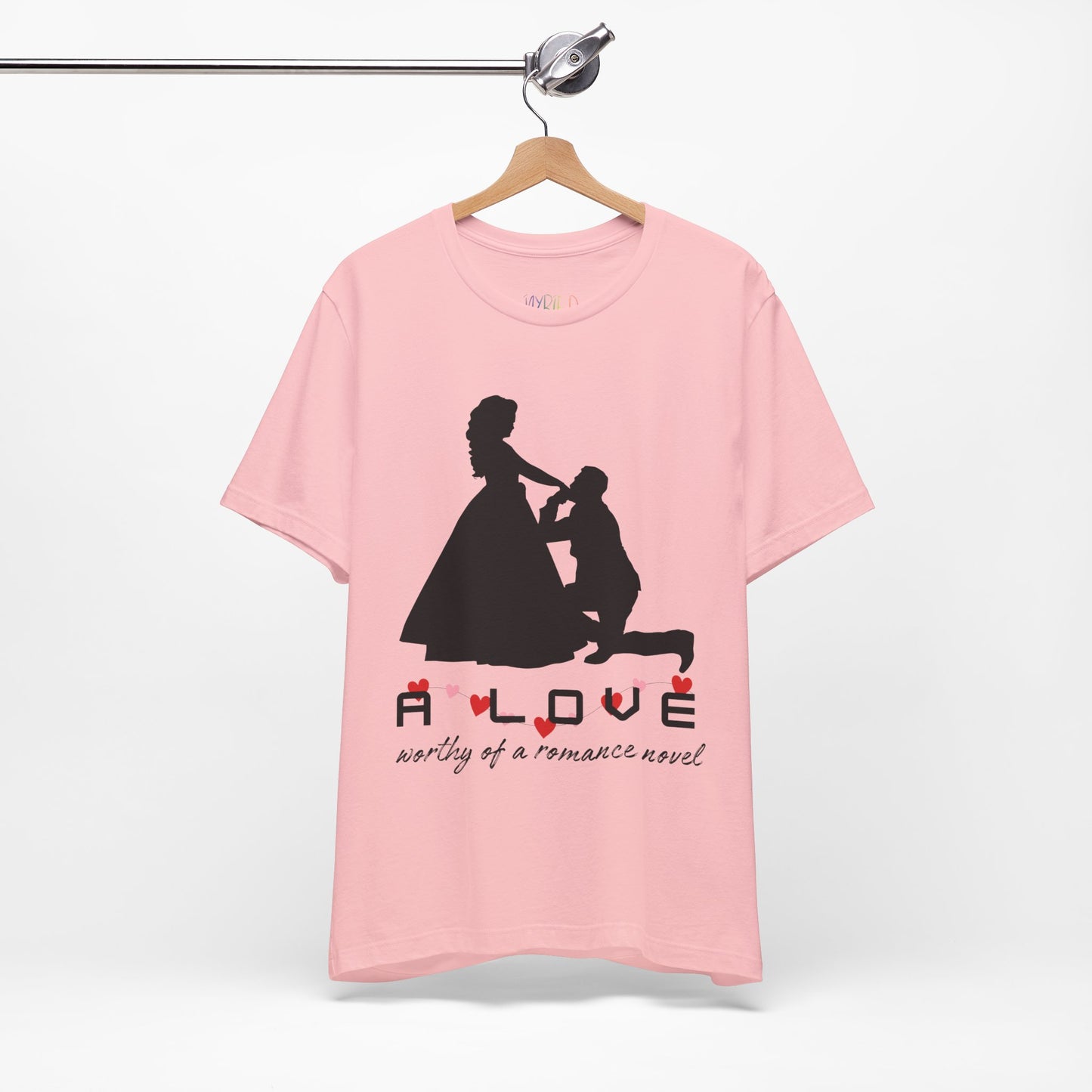 Pink t-shirt with black graphic if a man kneeling in front of a woman in a gown and text 'A LOVE worthy of a romance novel'