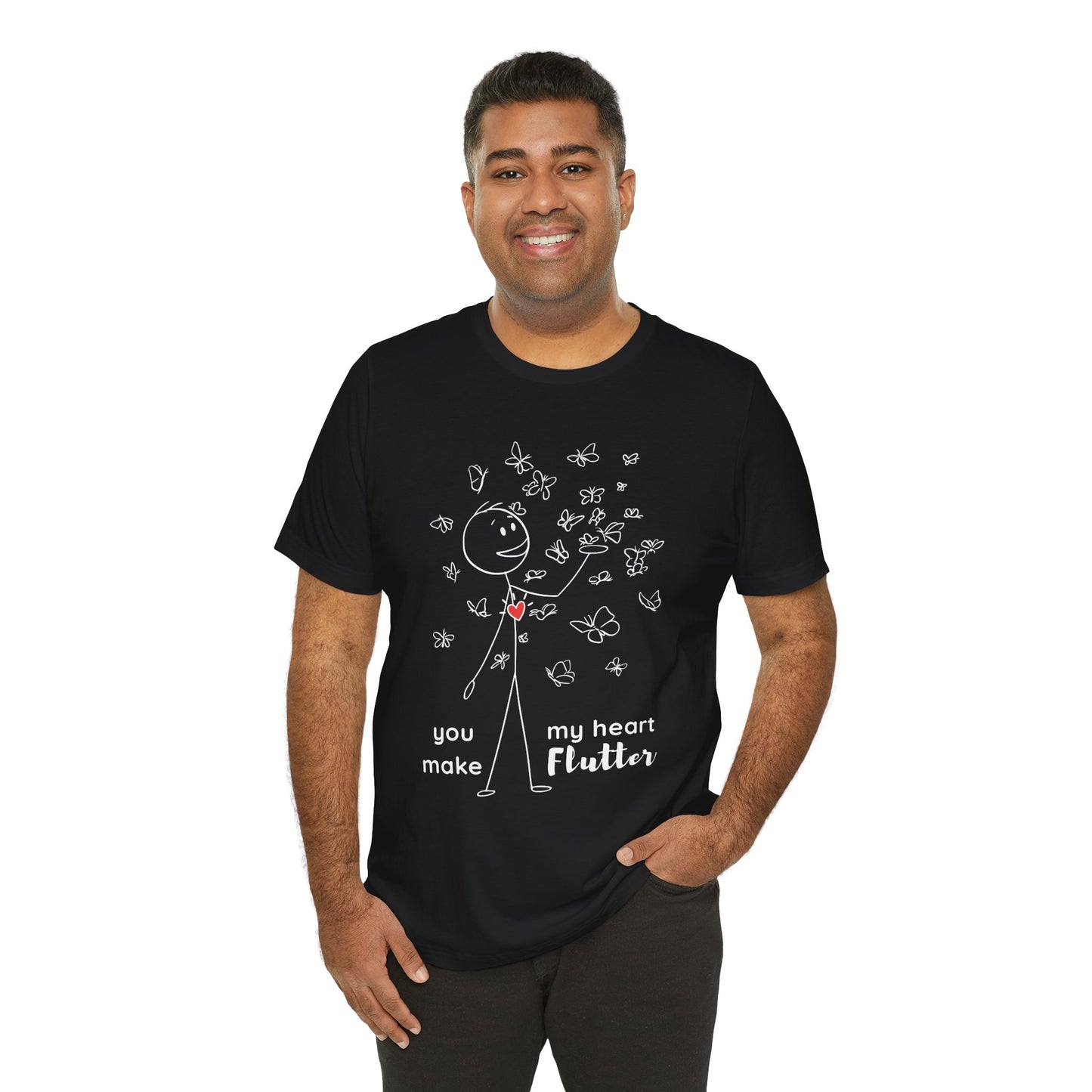 Man wearing a black t-shirt with a stick figure surrounded by butterflies and a red heart beating on his chest, text 'You Make My Heart Flutter'