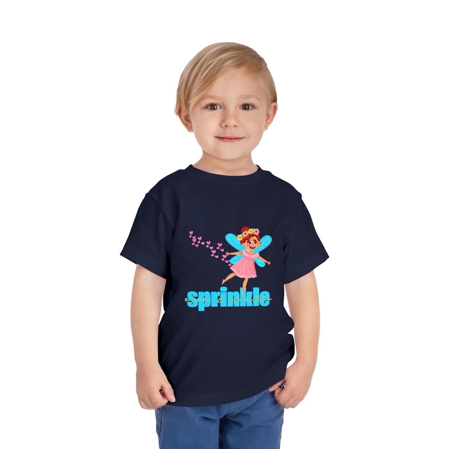 Child wearing a navy blue toddler t-shirt with a fairy graphic, hearts and 'sprinkle sass & sparkle' text