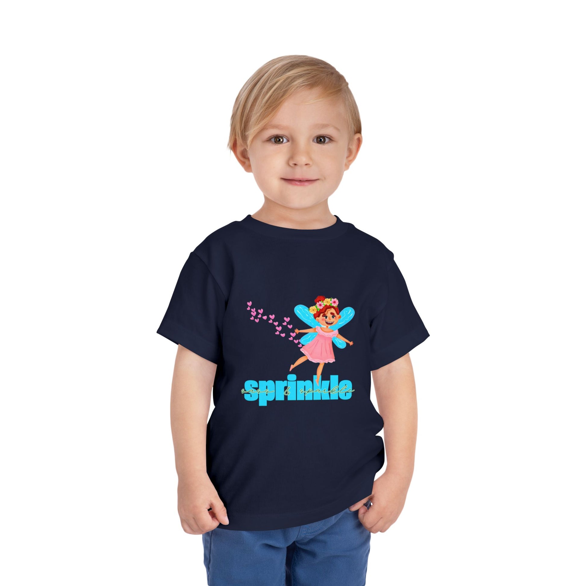 Child wearing a navy blue toddler t-shirt with a fairy graphic, hearts and 'sprinkle sass & sparkle' text