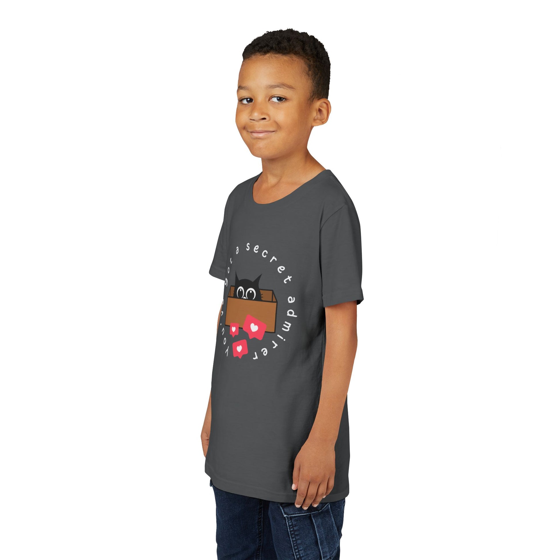 Boy wearing a gray t-shirt with a graphic of a cat peeking out of a box, heart social media bubbles and text 'You've Got A Secret Admirer' 