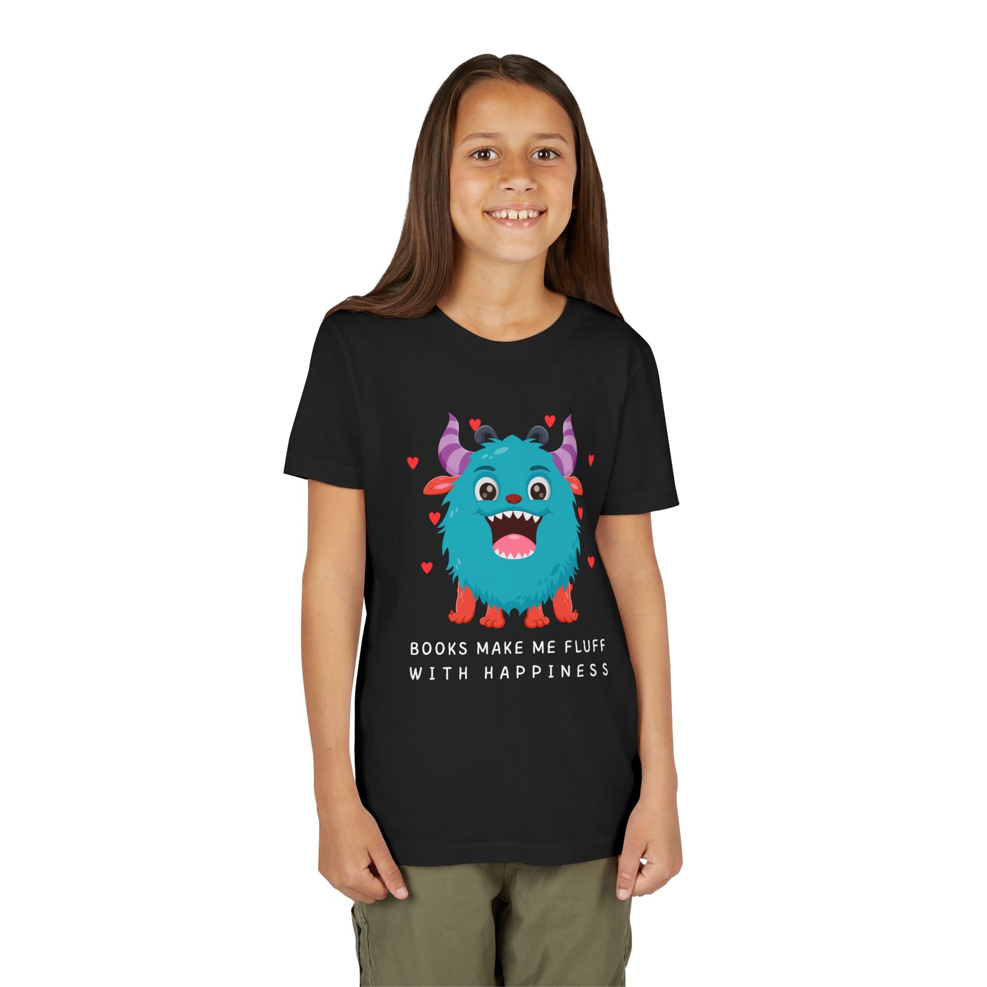 Girl wearing a black t-shirt with a joyful cartoon monster surrounded by hearts and text 'Books Make Me Fluff With Happiness'