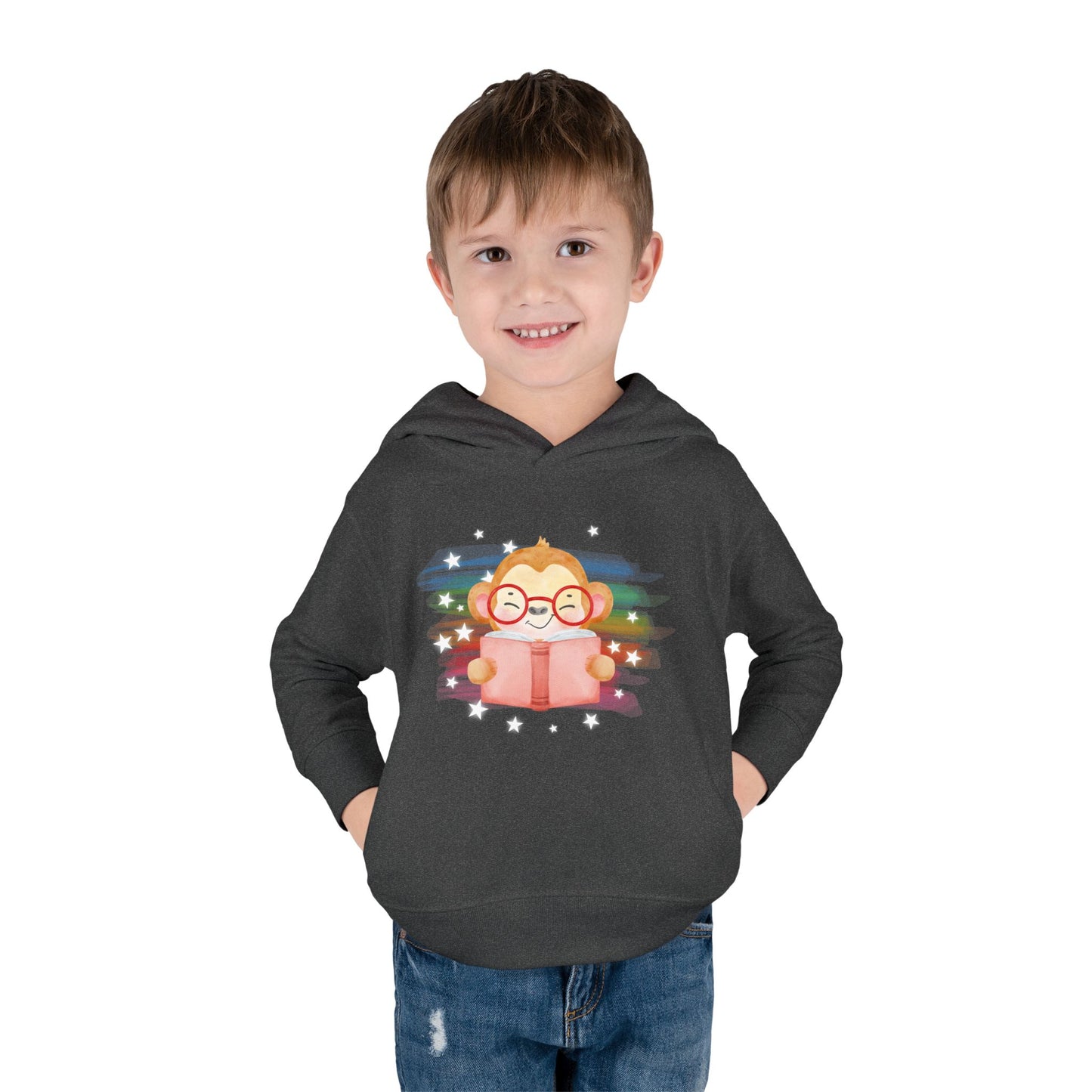 Boy wearing a dark gray toddler hoodie with a cartoon monkey wearing glasses, reading a book and surrounded by stars 