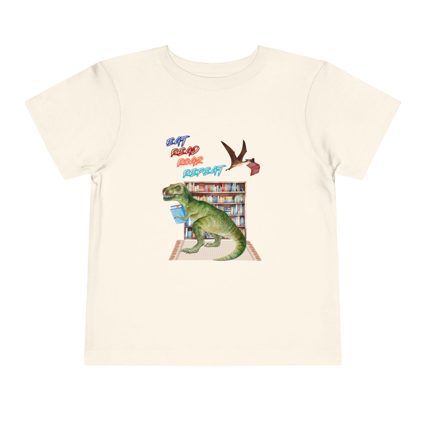 Beige toddler t-shirt with a t-rex dinosaur checking out a book at the library, a tera dactyl flying overhead with a book and text 'Eat, Read, Roar, Repeat' 