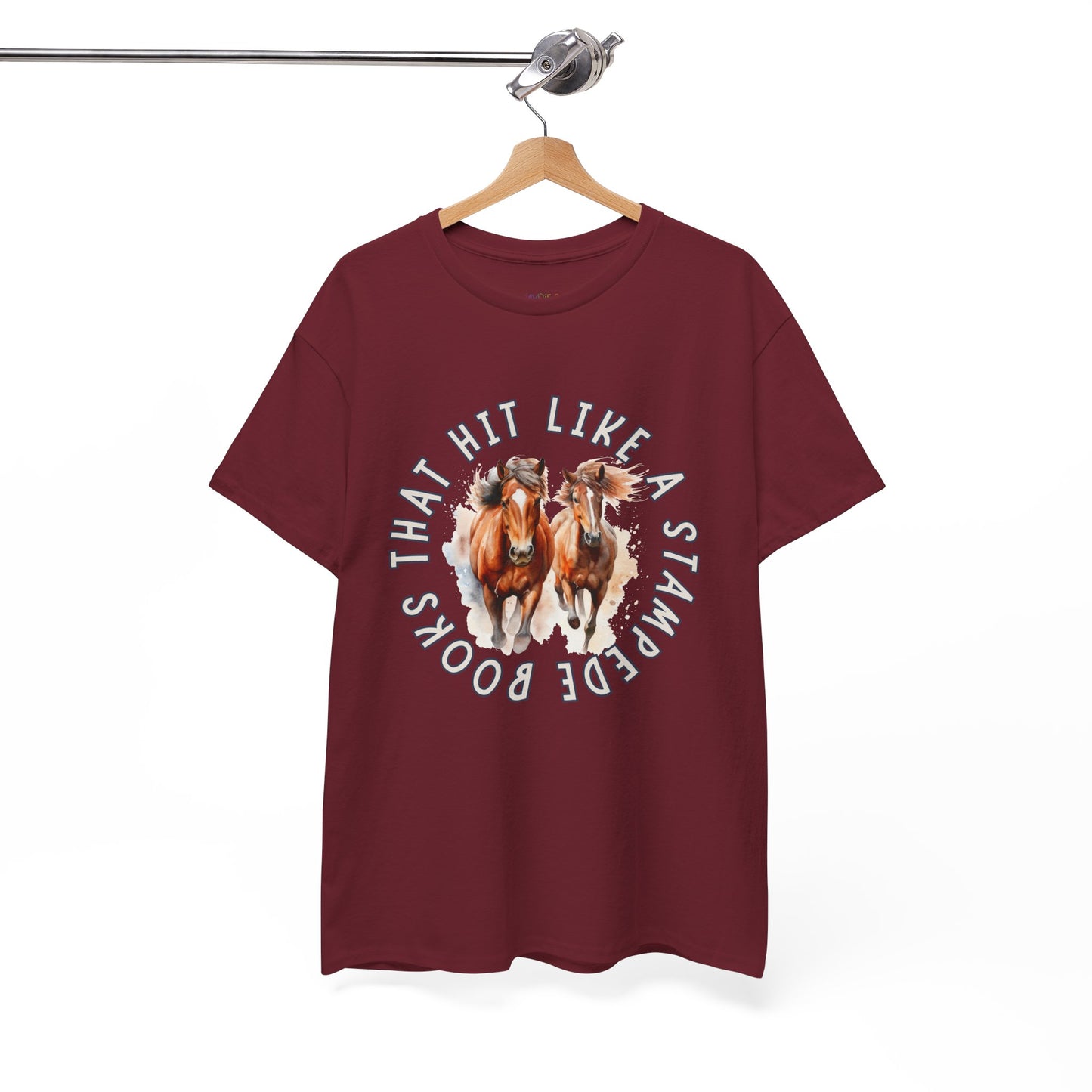 Maroon t-shirt with horses running out from the center of the shirt and circled by words 'Books That Hit Like a Stampede' 