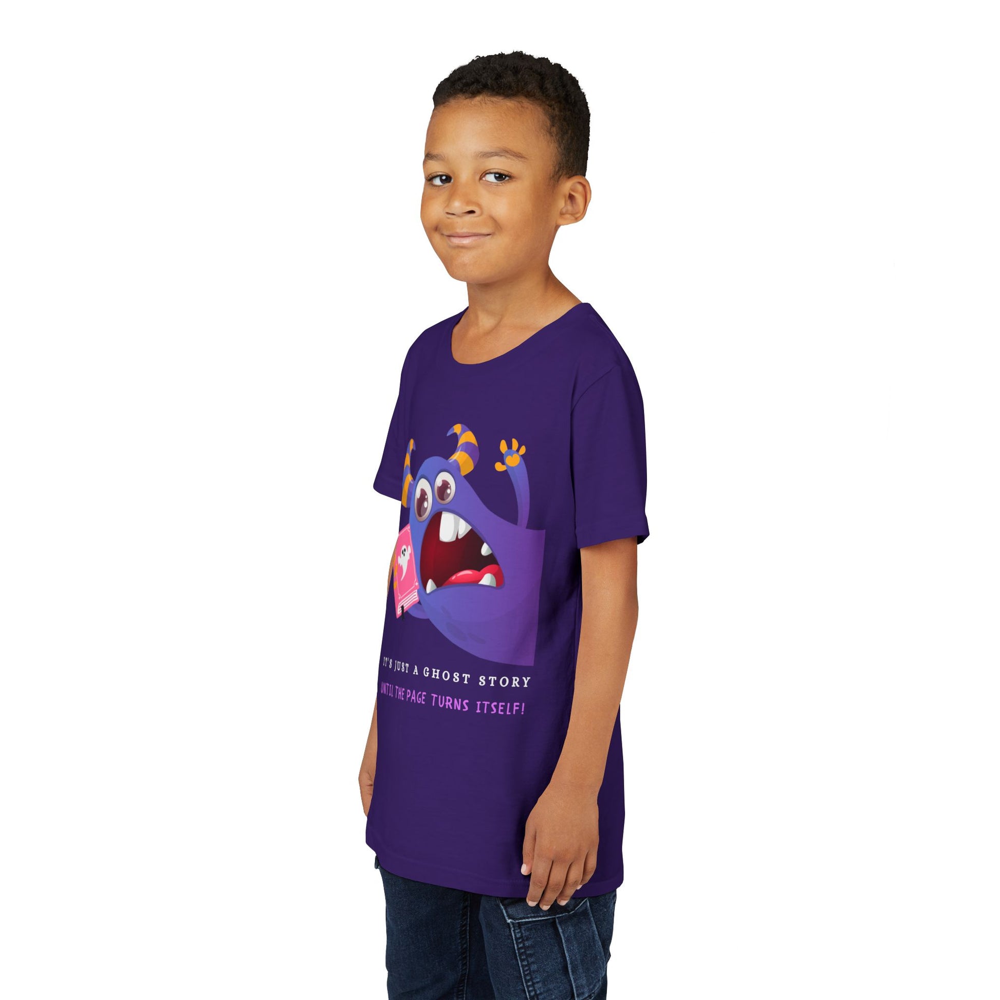 Boy wearing a purple t-shirt with a cartoon monster urgently jumping into frame with a gaping mouth, holding a book and text 'It's Just a Ghost Story Until The Page Turns Itself!'