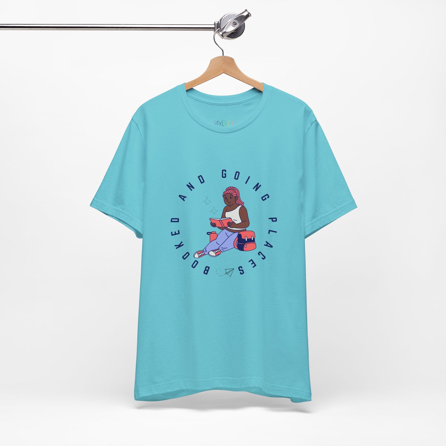 Aqua blue t-shirt with graphic design of a school girl sitting with a book and text 'Booked And Going Places'