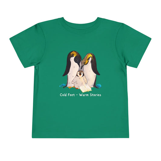 Green toddler t-shirt with penguin family design, an open book and 'Cold Feet - Warm Stories' text 