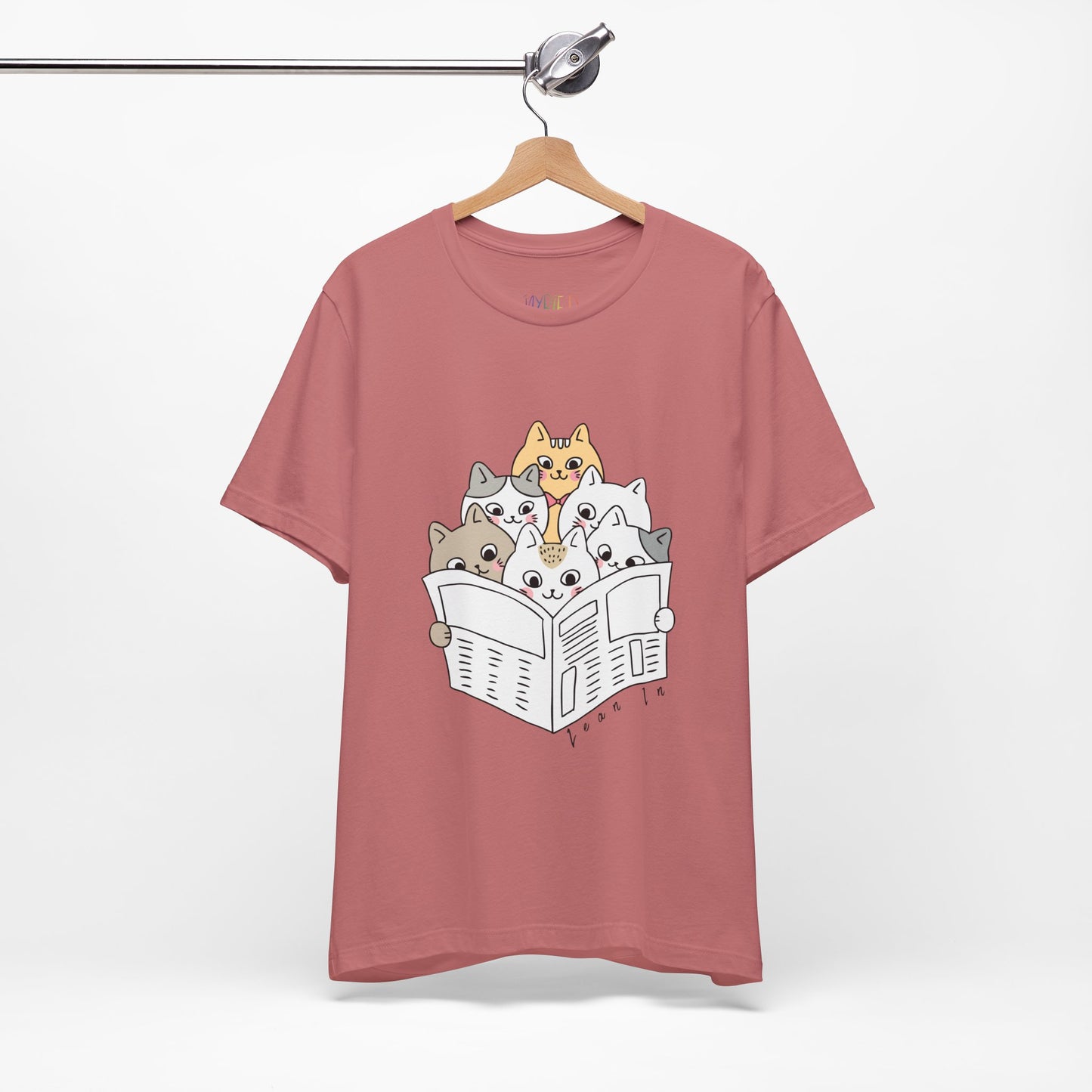 Mauve t-shirt with cartoon cats squeezed in to read the newspaper and text 'Lean In'