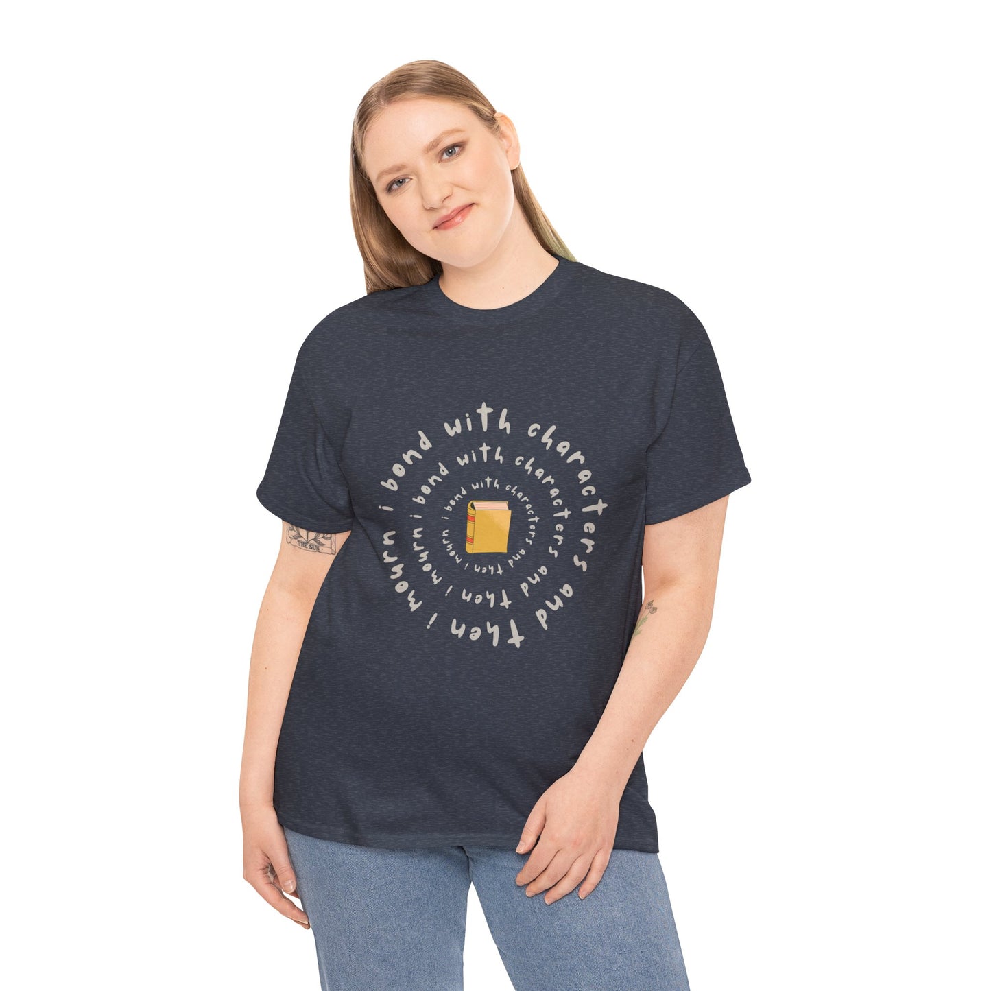 Woman wearing a heather navy blue t-shirt with a small book at the center and layered spiral text 'I Bond With Characters & Then I Mourn'