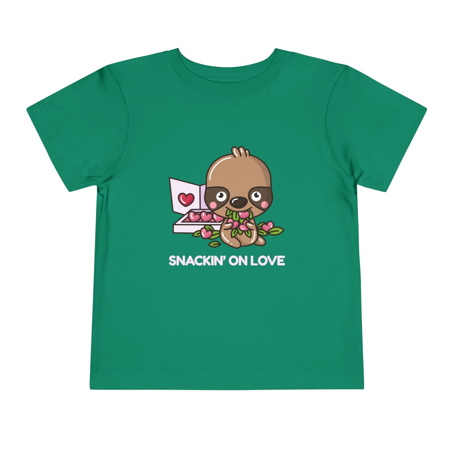 Green toddler t-shirt with a cartoon eating a box of heart shaped candies, text 'SNACKIN' ON LOVE'
