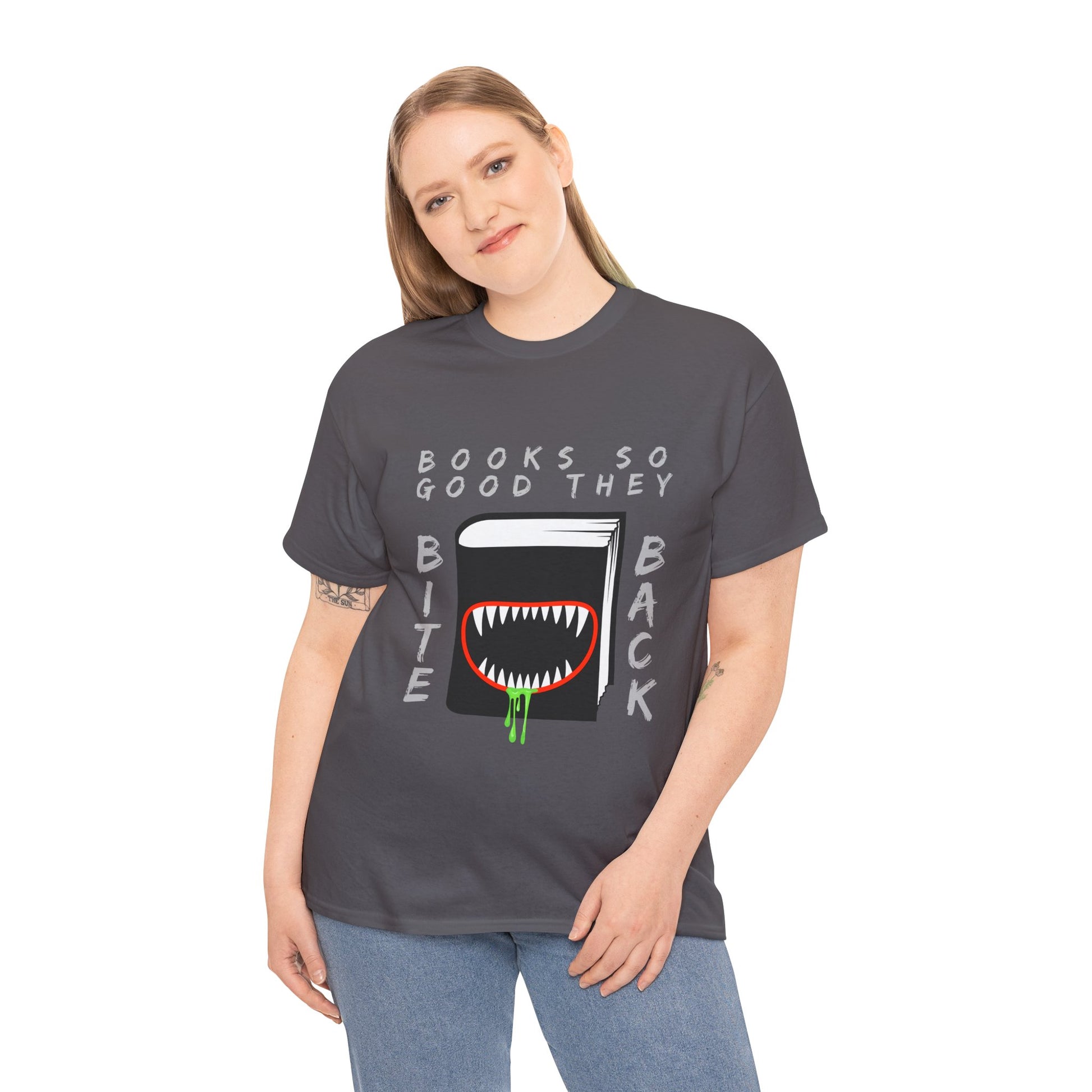 Woman wearing a gray t-shirt with a graphic design of a book with a drooling monster mouth and text 'Books So Good They Bite Back' on a hanger against a white background