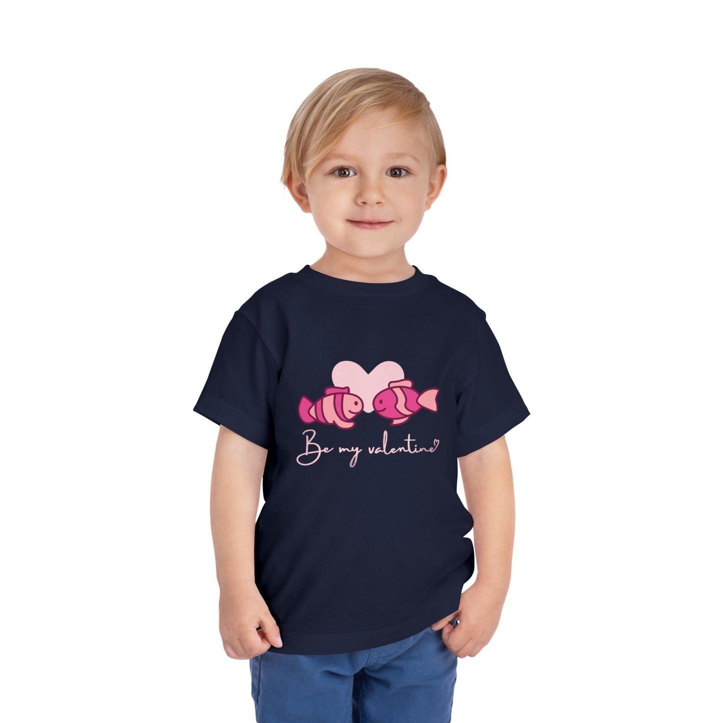 Child wearing a navy blue toddler t-shirt with two pink fish, a heart and 'Be My Valentine' text 