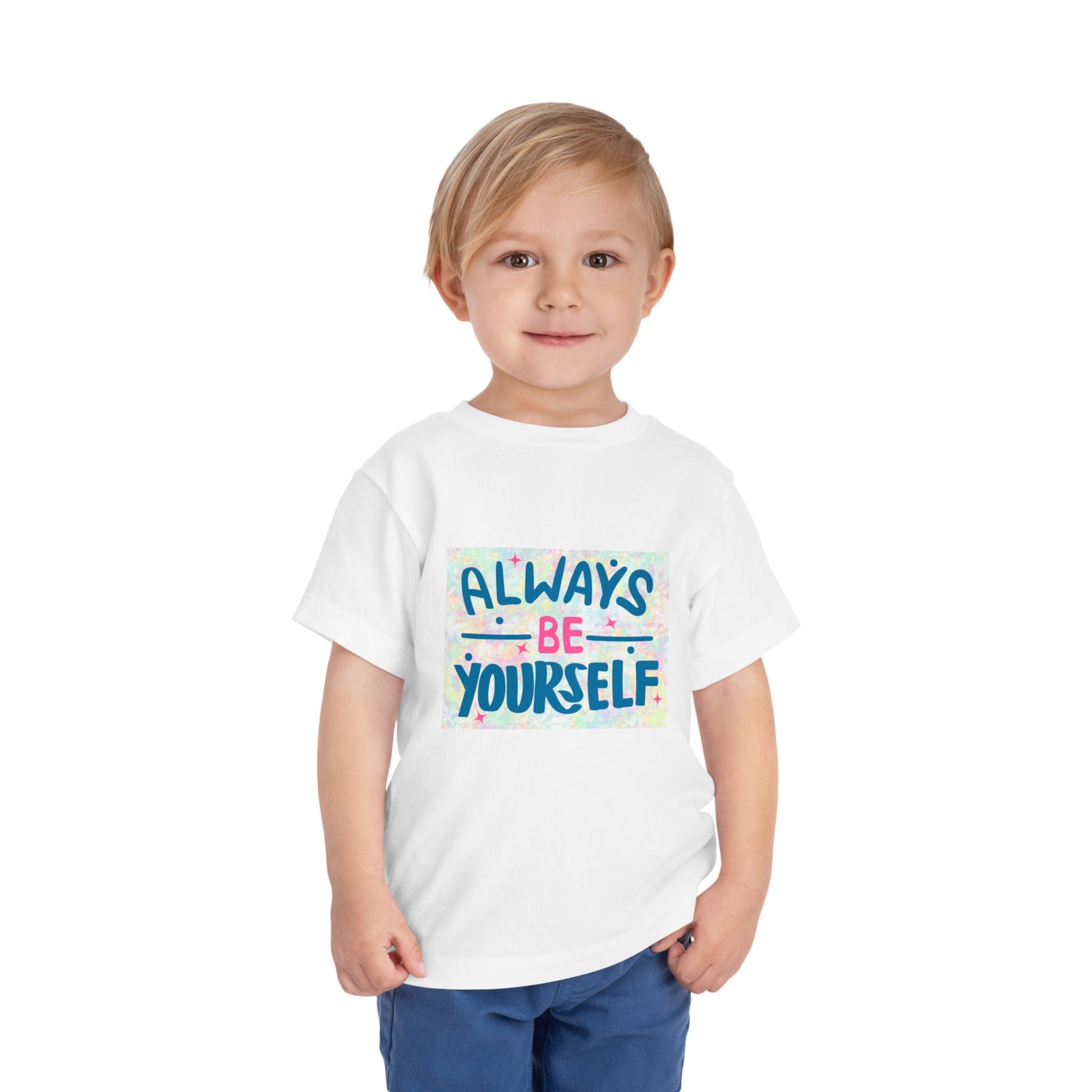 Child wearing a toddler t-shirt featuring text 'Always Be Yourself' with a colorful pastel background
