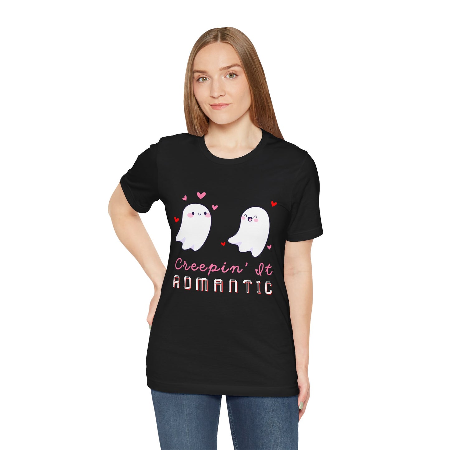 Woman wearing a black t-shirt with two flirty ghosts, scattered hearts and text 'Creepin' It Romantic' 