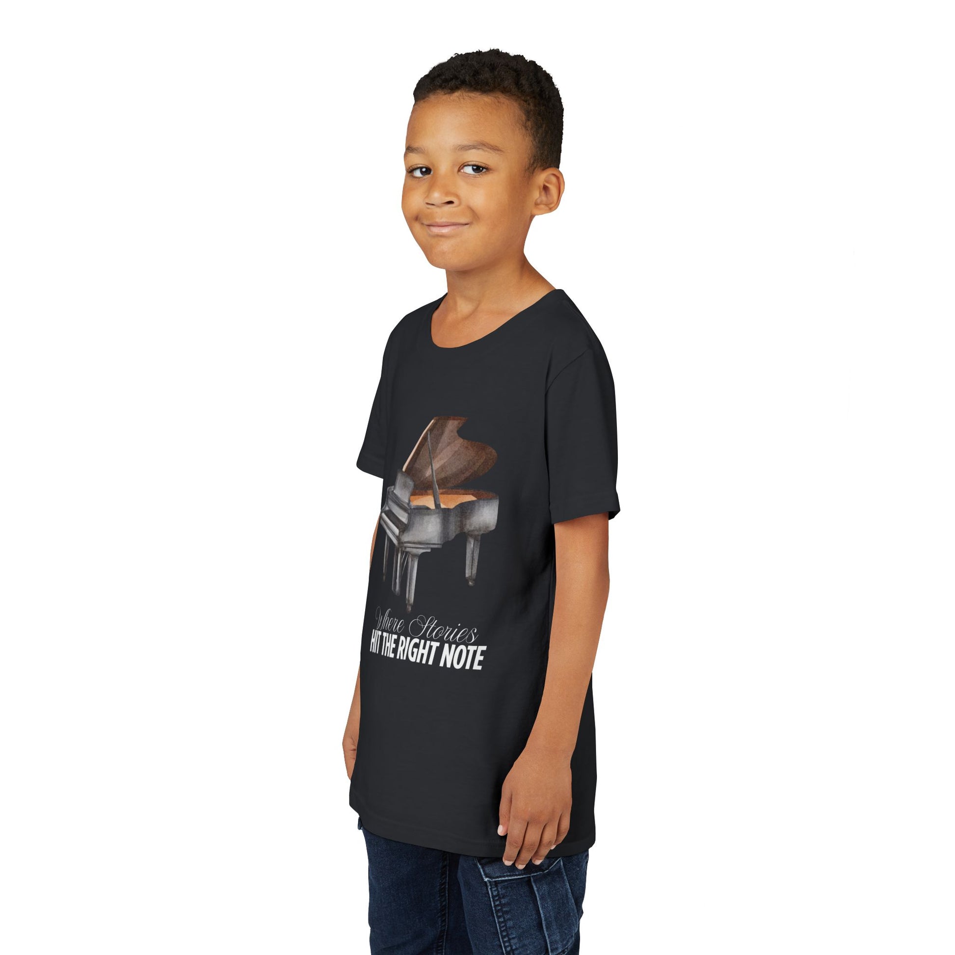 Boy wearing a black t-shirt with a grand piano graphic and text 'Where Stories Hit The Right Note'